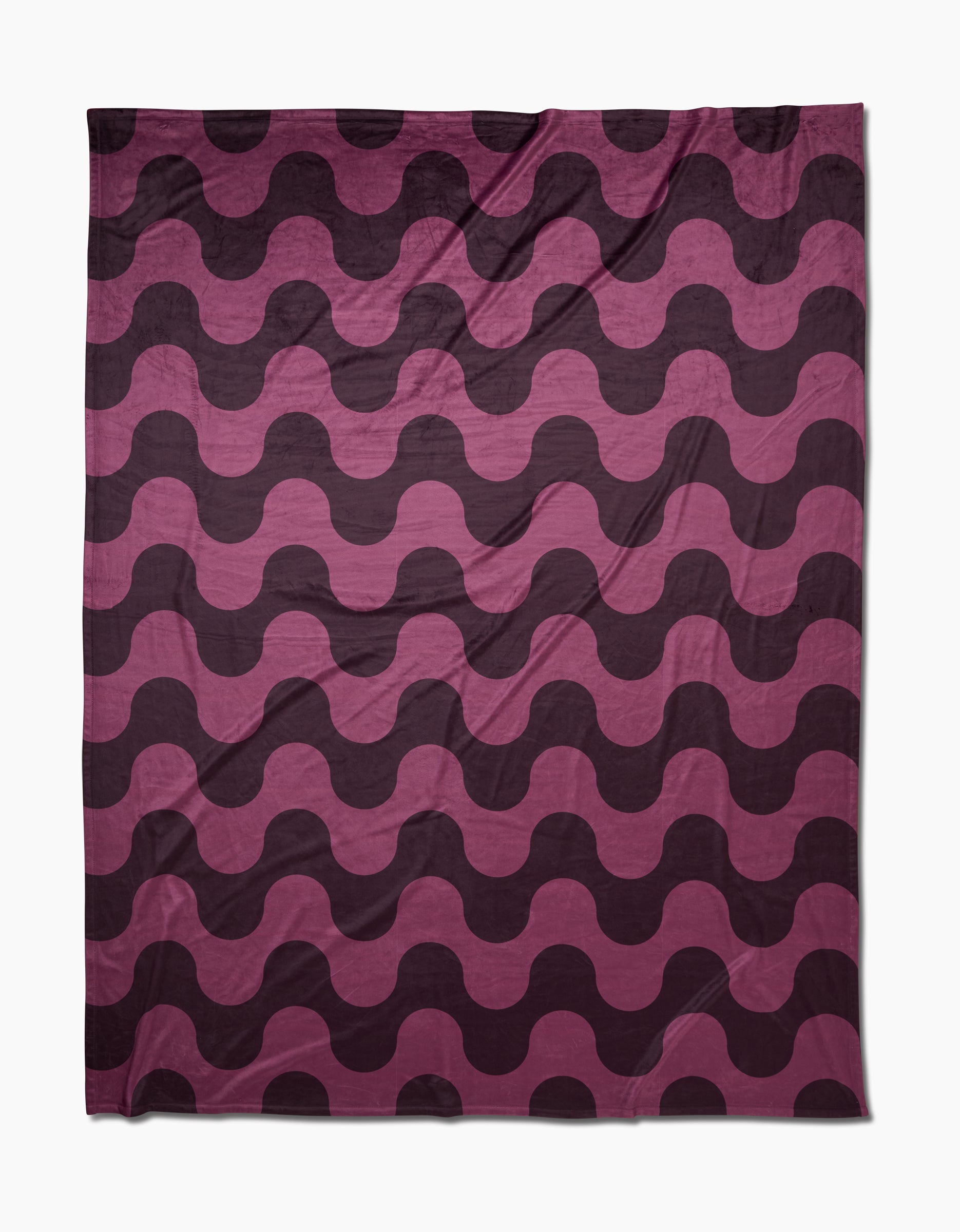The Geometry Groove With Me Butter Blanket features silky-soft, recycled fabric with bold, wavy stripes in dark purple and pink for a stylish, modern vibe. Alternating waves create a dynamic look while keeping you cozy.