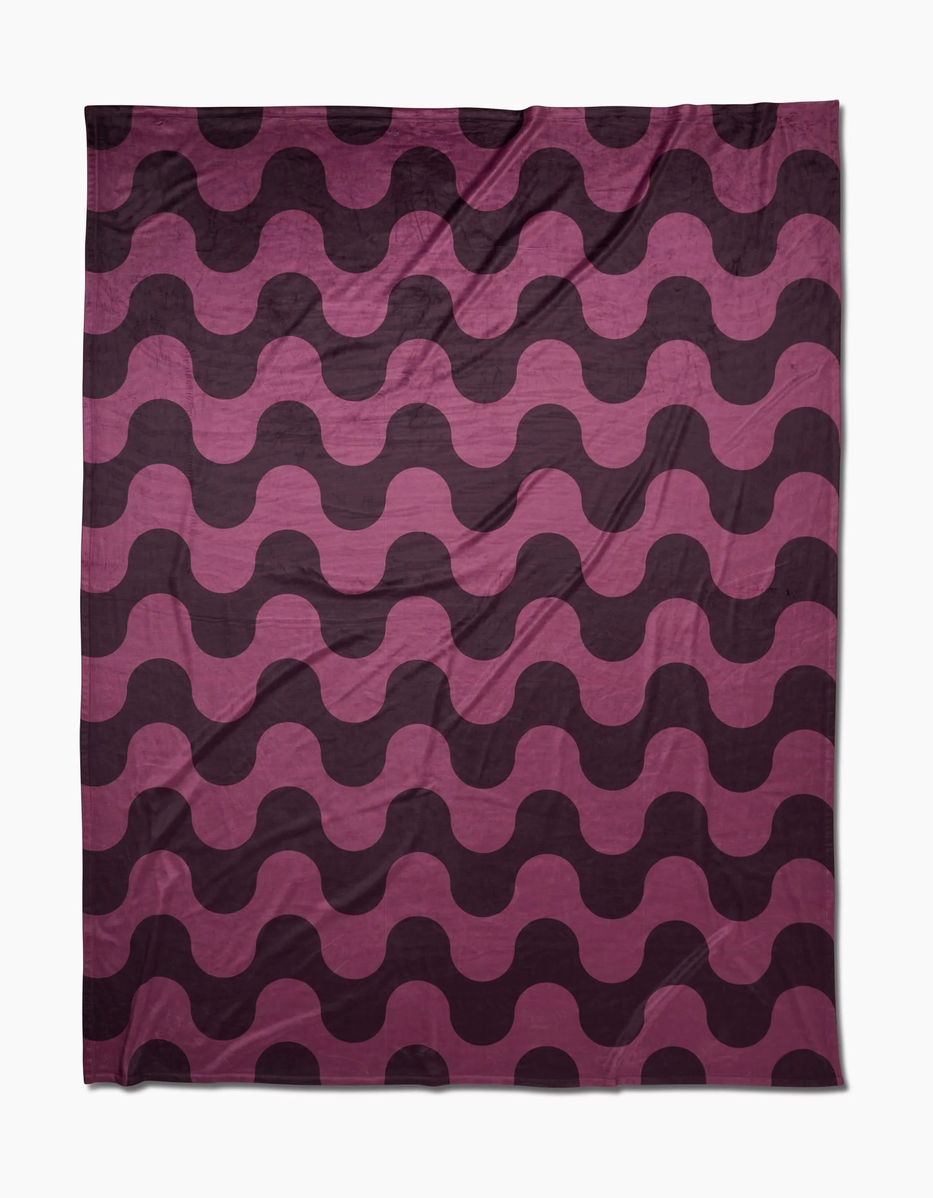 The Geometry Groove With Me Butter Blanket features silky-soft, recycled fabric with bold, wavy stripes in dark purple and pink for a stylish, modern vibe. Alternating waves create a dynamic look while keeping you cozy.