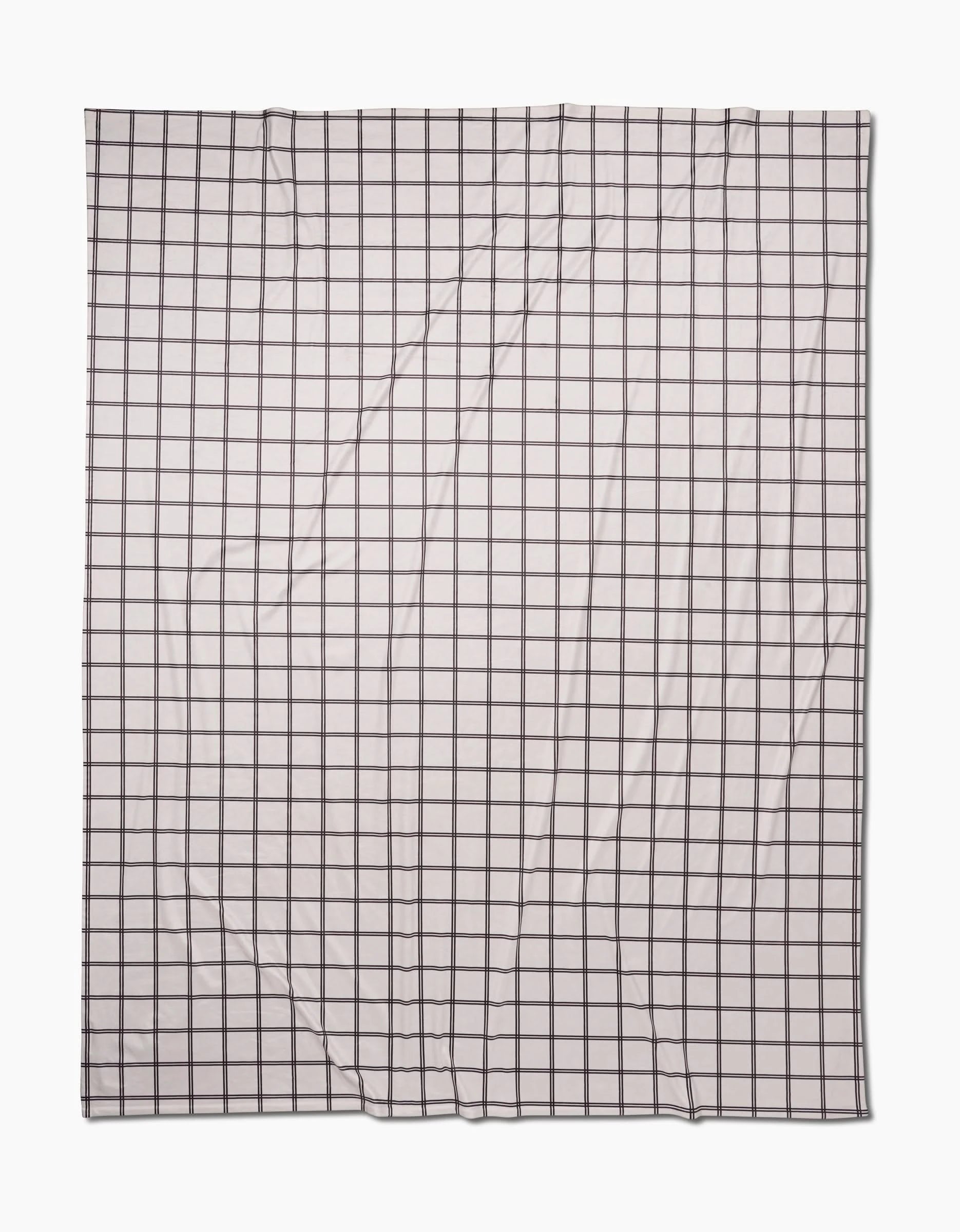 A rectangular, white Moon Butter Blanket by Geometry, made from recycled materials and featuring a black grid of evenly spaced lines, is laid flat with slight visible wrinkles.