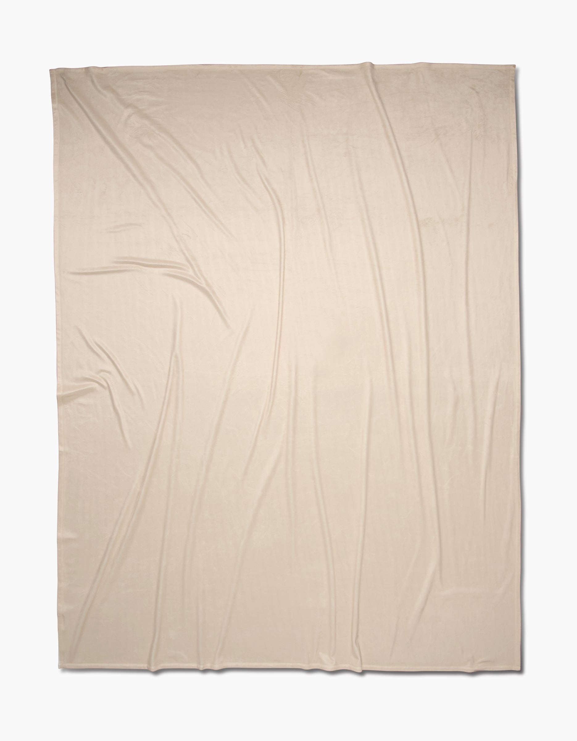 A light beige, rectangular Soft Glow blanket by GEOMETRY is displayed flat with gentle, natural folds. Made from eco-friendly recycled materials, the fabric rests on a plain white background.