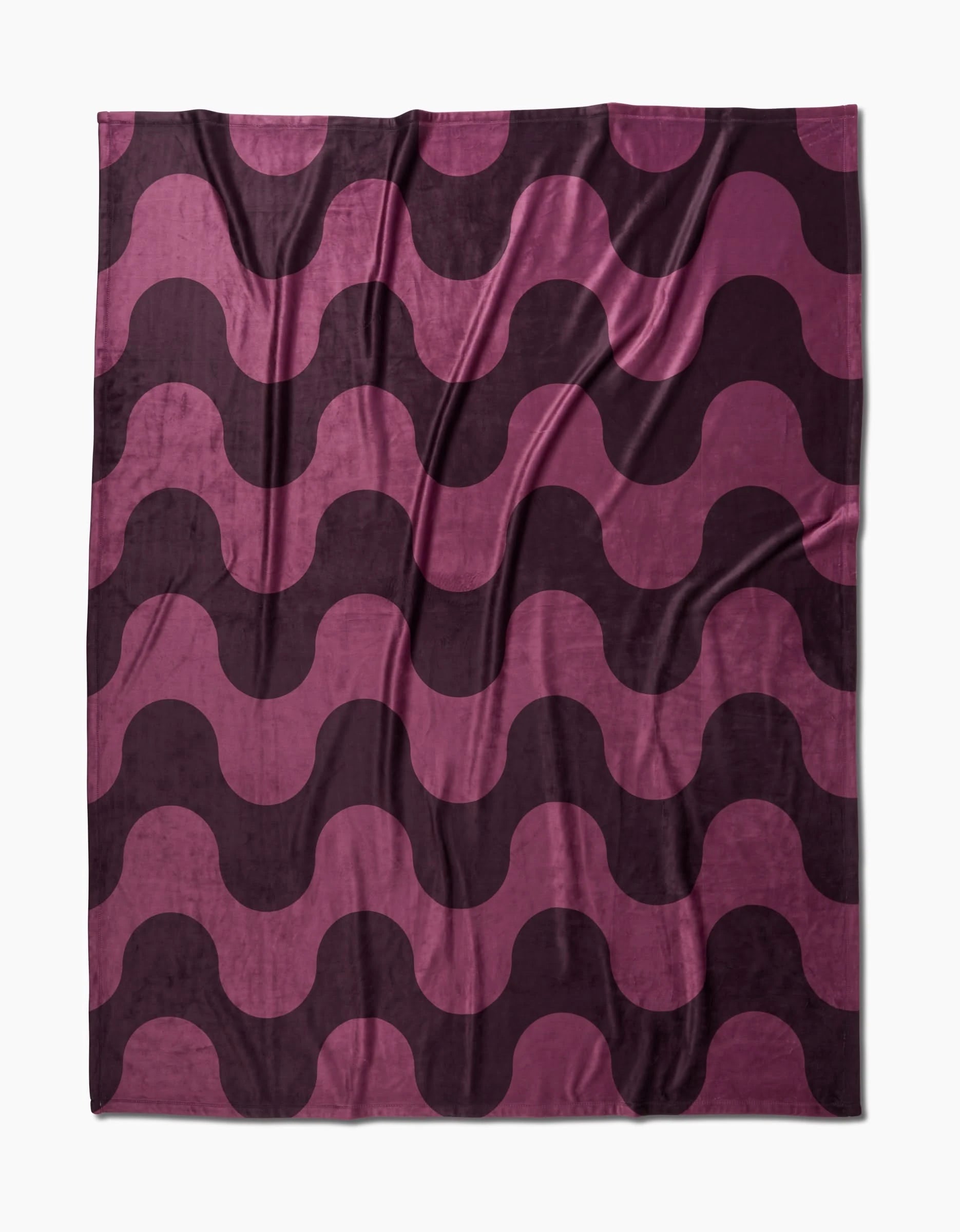The Geometry Groove With Me Butter Blanket features a wavy, repeating geometric pattern in dark purple and magenta, delivering silky softness with a bold, modern design.
