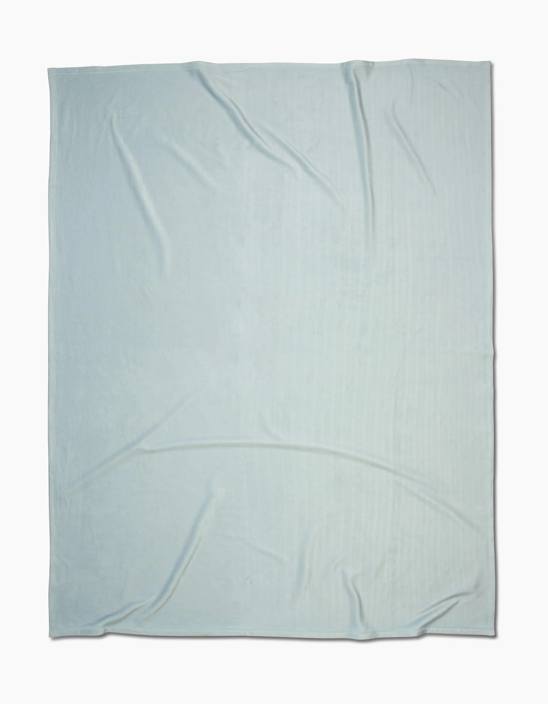 A Mint Drift Butter Blanket by GEOMETRY, featuring silky softness and subtle wrinkles, is spread out flat against a white background.