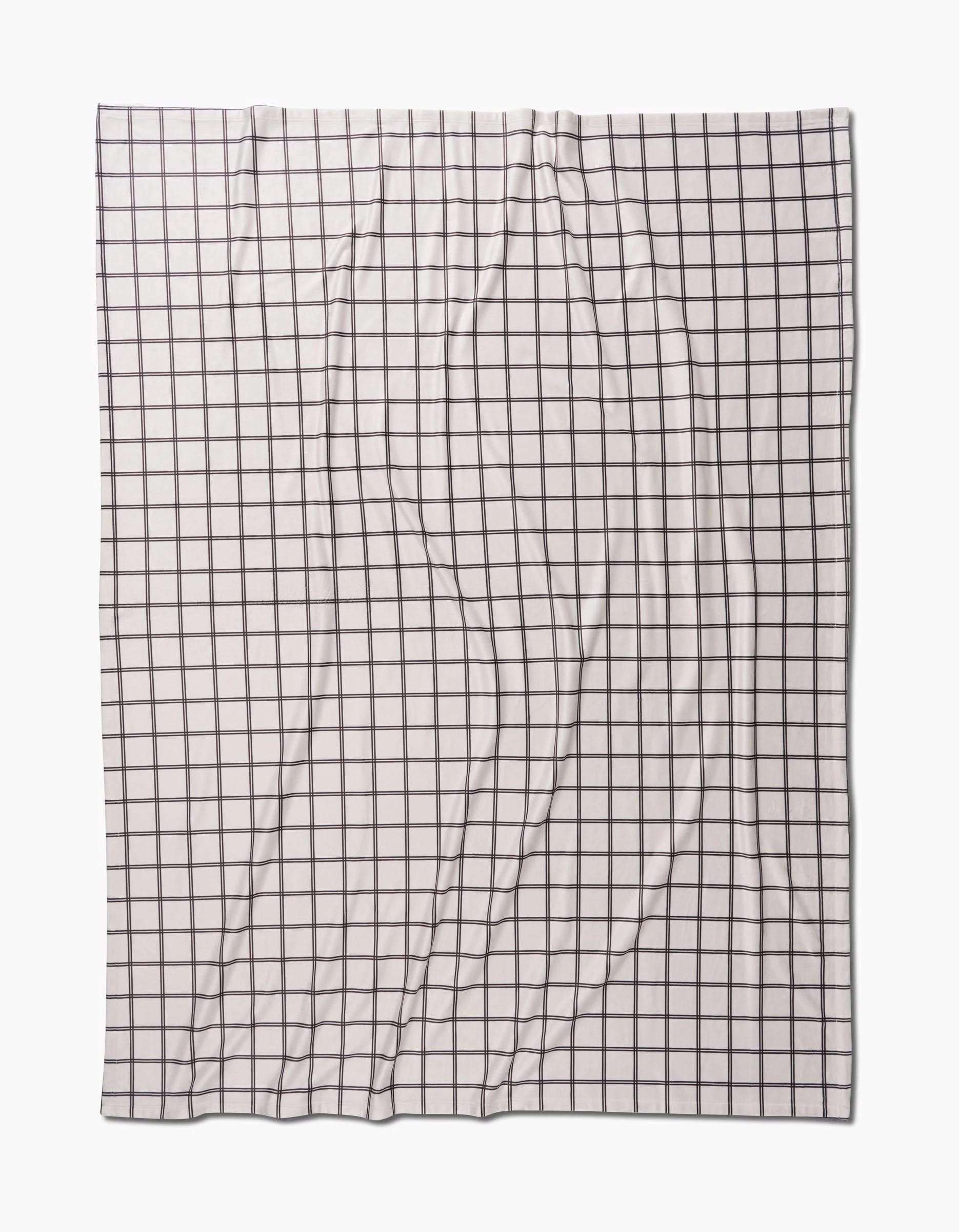 The Moon by Geometry is a white fabric featuring a black grid of evenly spaced squares, shown flat with natural wrinkles and folds, offering silky softness like a Butter Blanket.