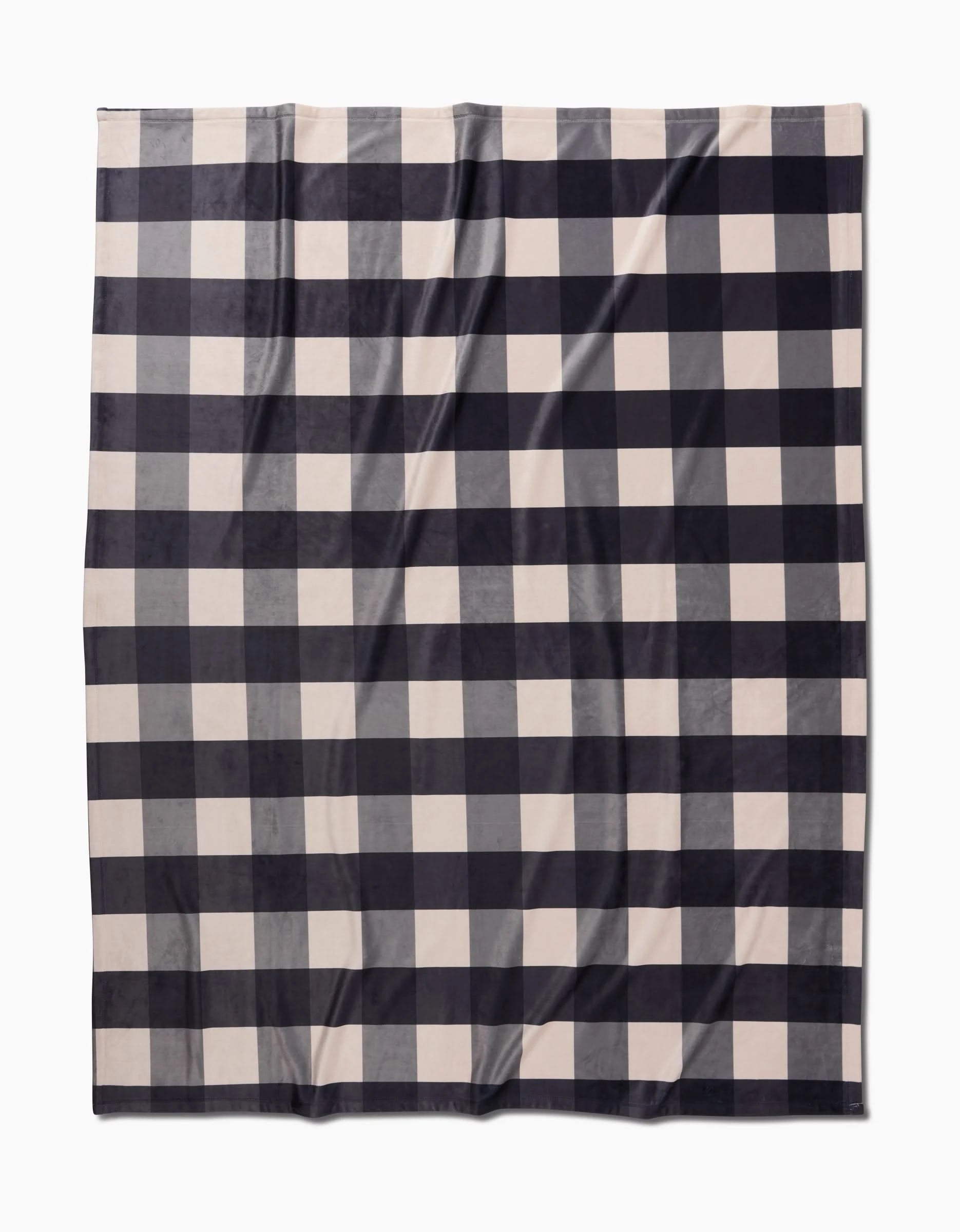 The Geometry Snowy Gingham is a rectangular Butter Blanket with a black and white buffalo plaid pattern, crafted for silky softness and shown laid flat on a white background.