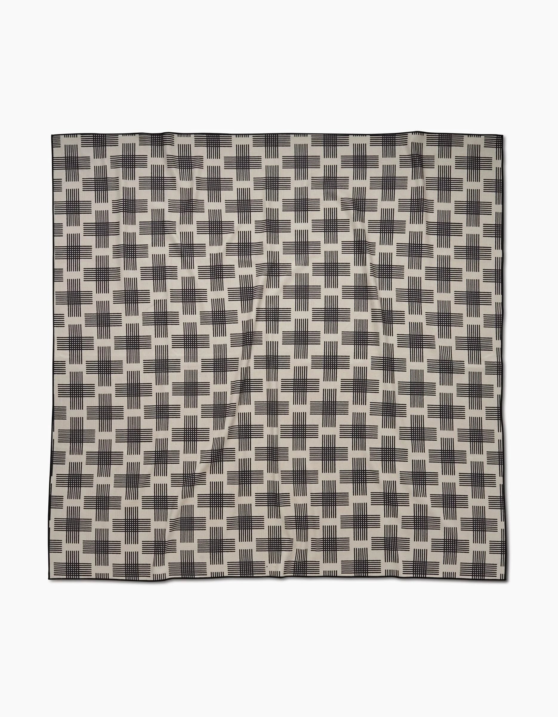 The Cross Hatch by Rosa Kichline is a square beach blanket crafted from quick-drying recycled materials, featuring a repeating black rectangular geometric pattern on beige with a thin black border.