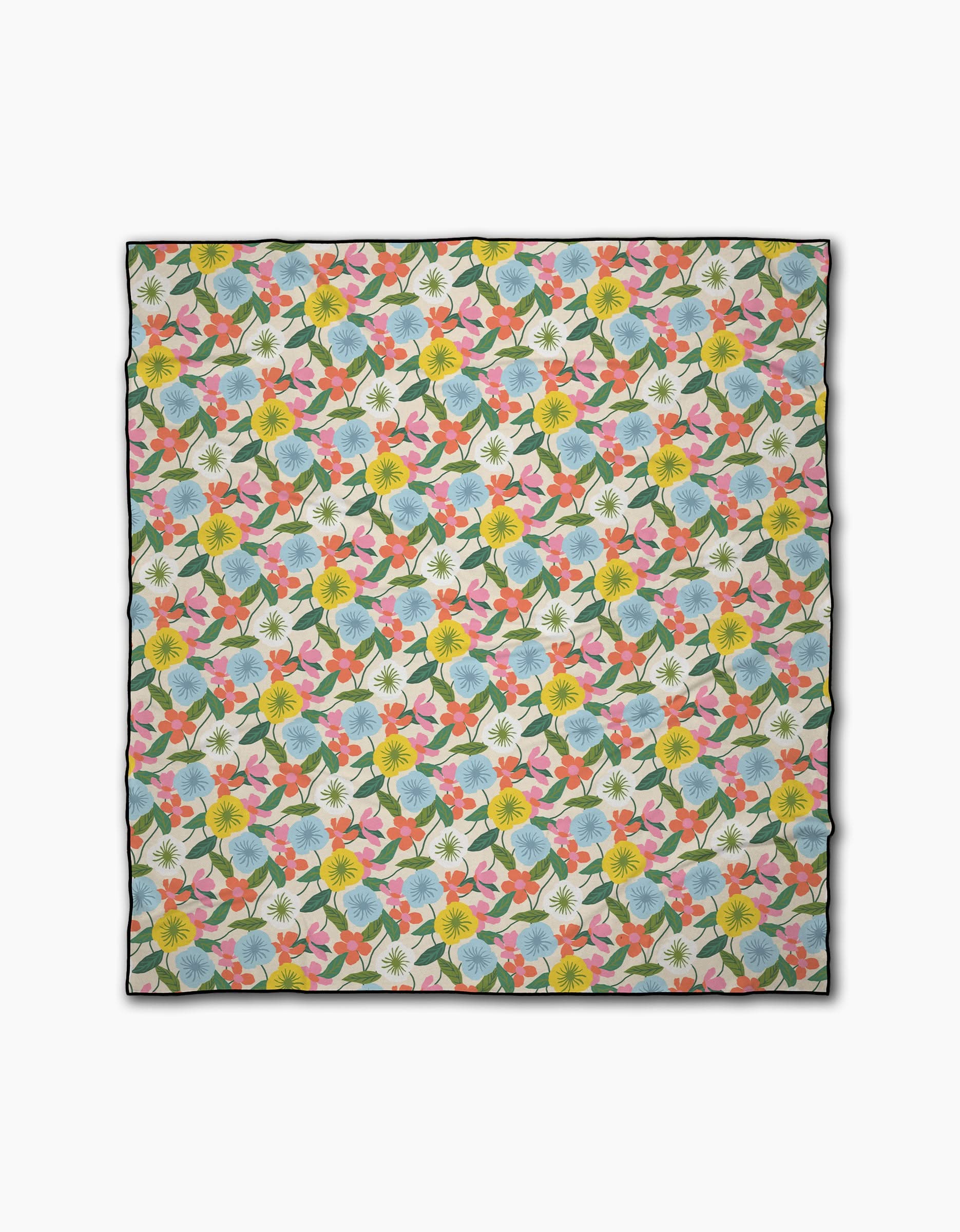 The New Mercies beach blanket by Susan Heid is a rectangular quick-drying design with yellow, pink, and blue flowers plus green leaves on white, finished with a thin black border for style.