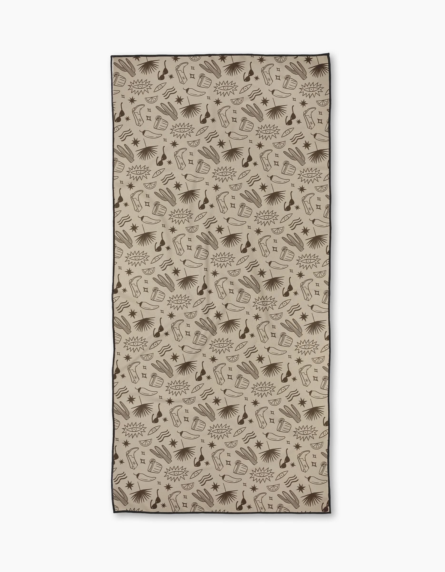 The Bonfire Nights beach towel by Geometry features a rectangular beige design with a dark brown camera, mug, book, shoe, and star pattern. Made from quick-drying recycled materials for eco-friendly style.