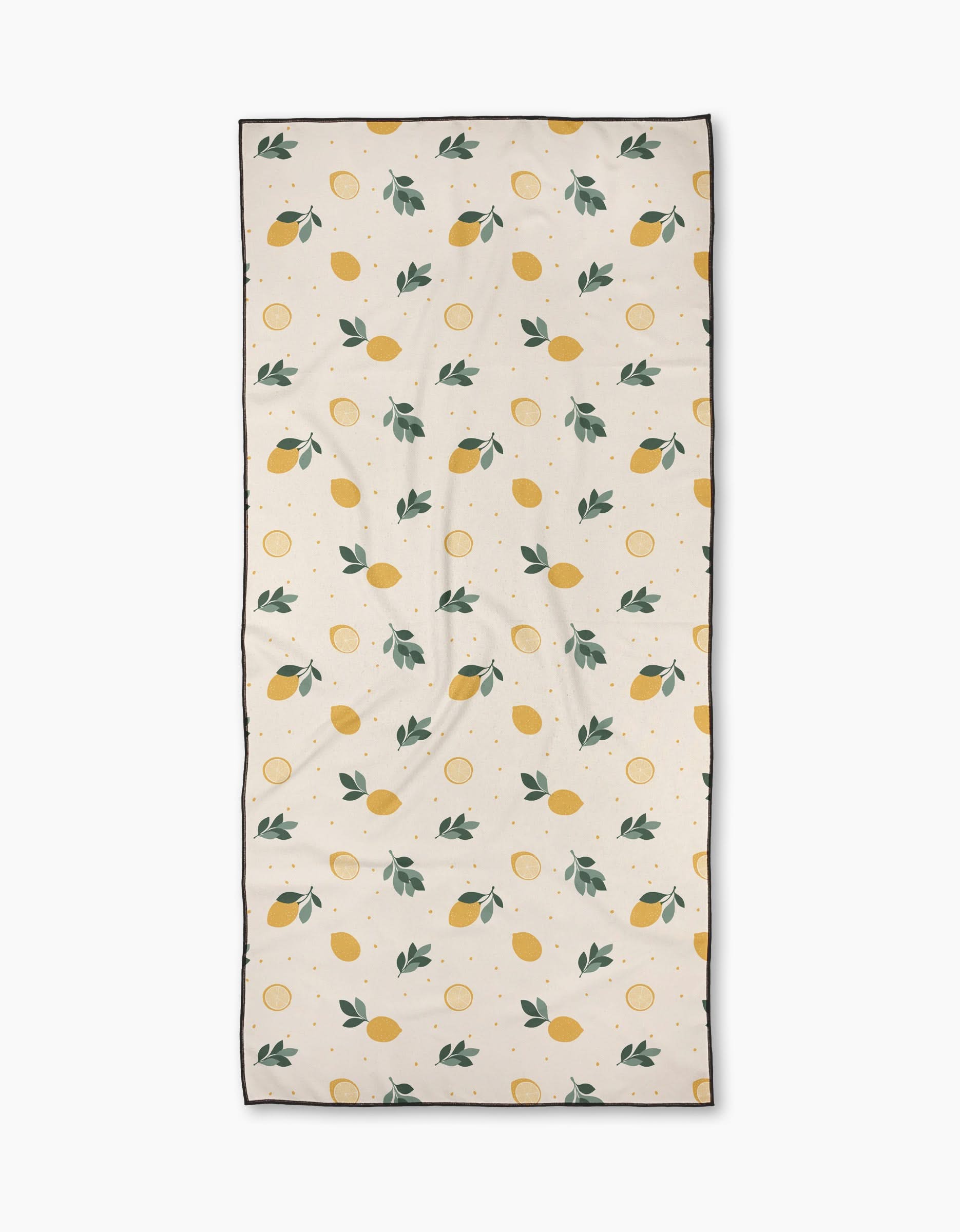 The Freshly Picked beach towel by Sara Mari features a rectangular beige micro-loop fabric with yellow lemons, lemon slices, and green leaves, bordered by a thin black edge. Its even design offers stylish looks and quick-drying comfort for beach days.