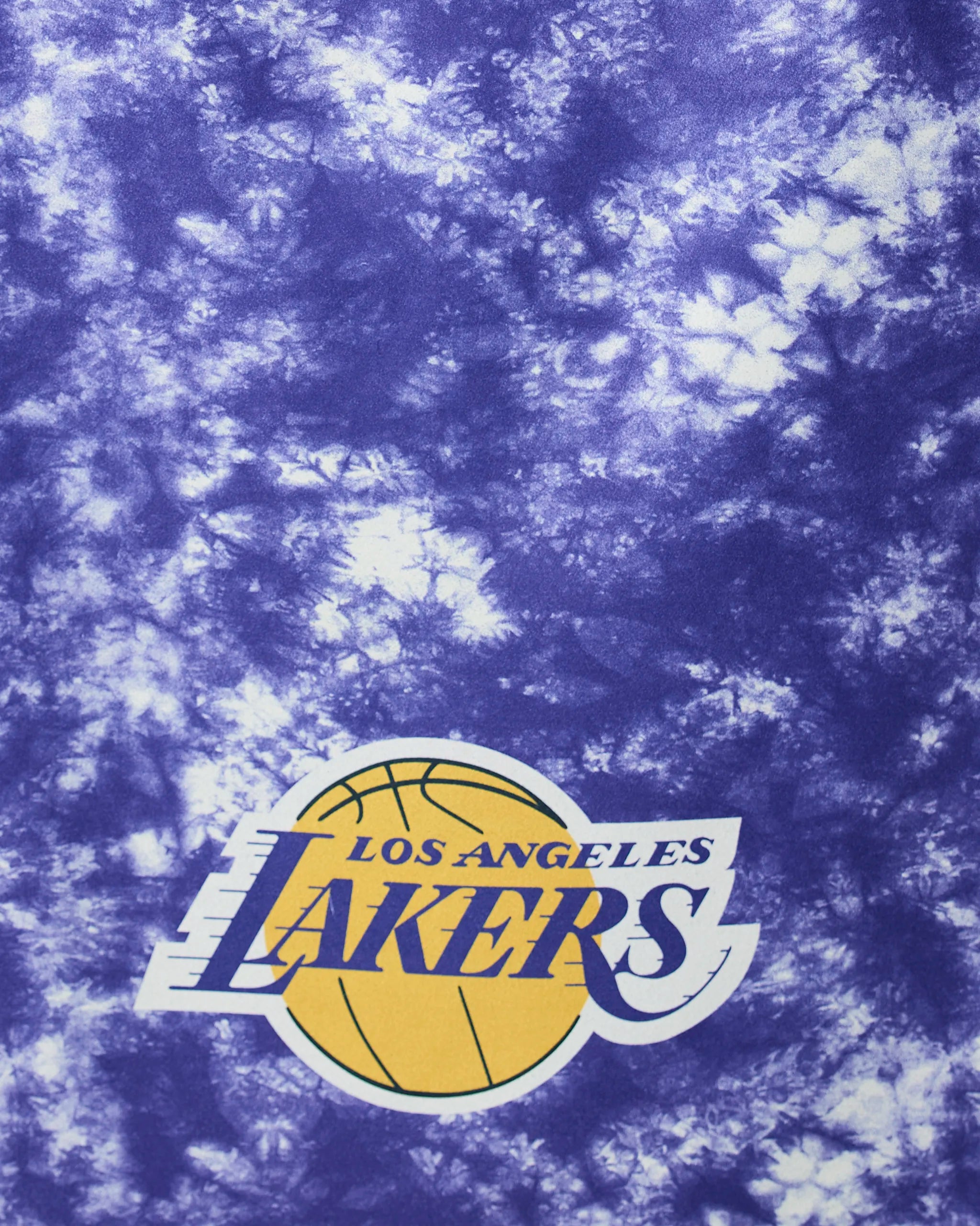 A close-up of Geometrys Lakers Flash fabric shows purple and white tie-dye with the Los Angeles Lakers logo, a yellow basketball, and bold lettering.