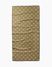 The Lina towel by Anna Christian is a rectangular olive green quick-drying piece with small white X patterns and a thin black border, shown laid flat with gentle folds on a white background.