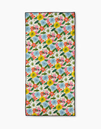 The New Mercies recycled beach towel by Susan Heid features a vibrant floral design—yellow, blue, pink, and red flowers with green leaves on white—plus a thin black border. Quick-drying and ideal for stylish days by the water.