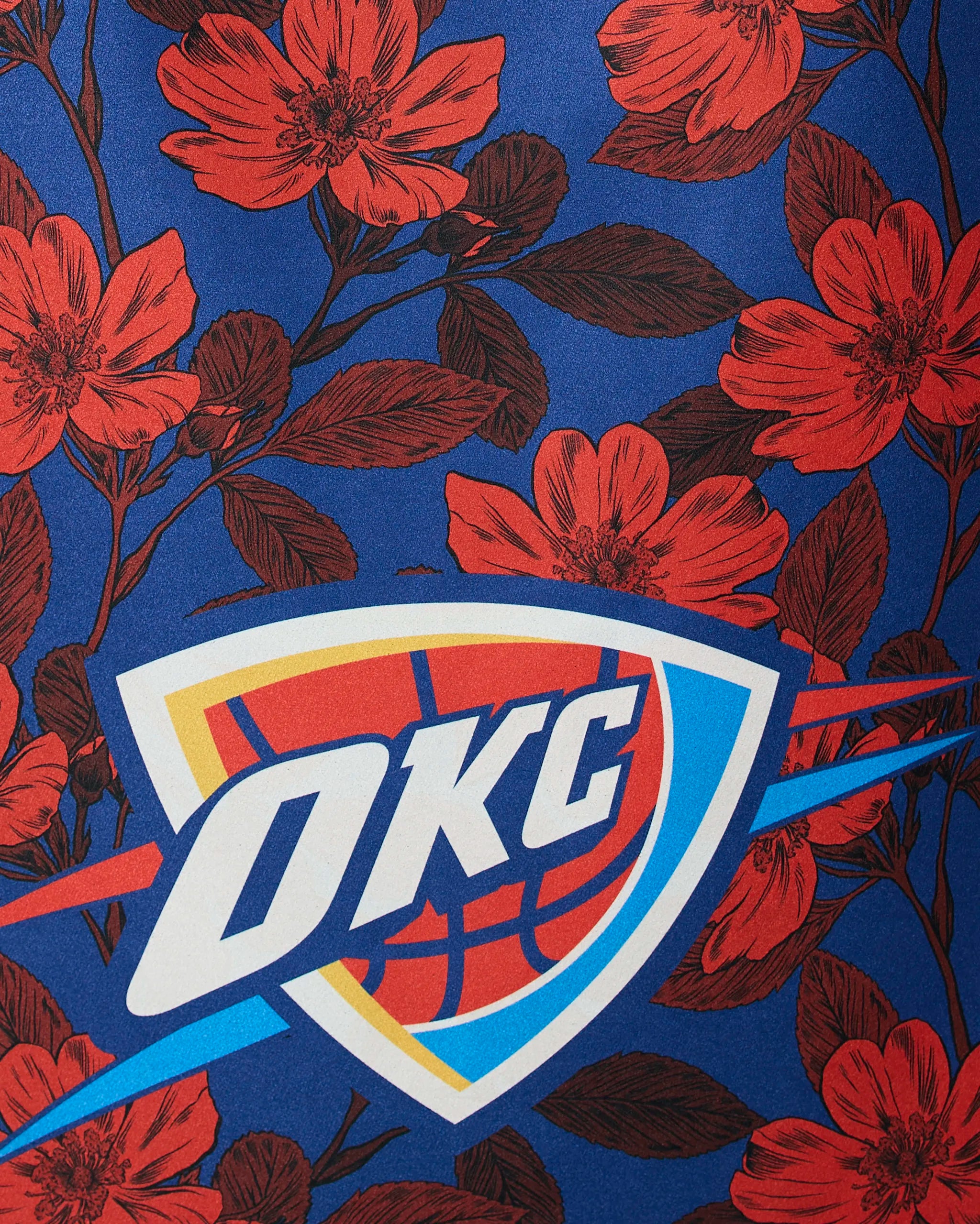The image features the OKC Floral design by Geometry, showcasing the Oklahoma City Thunder logo on a blue background with red flowers and dark leaves.