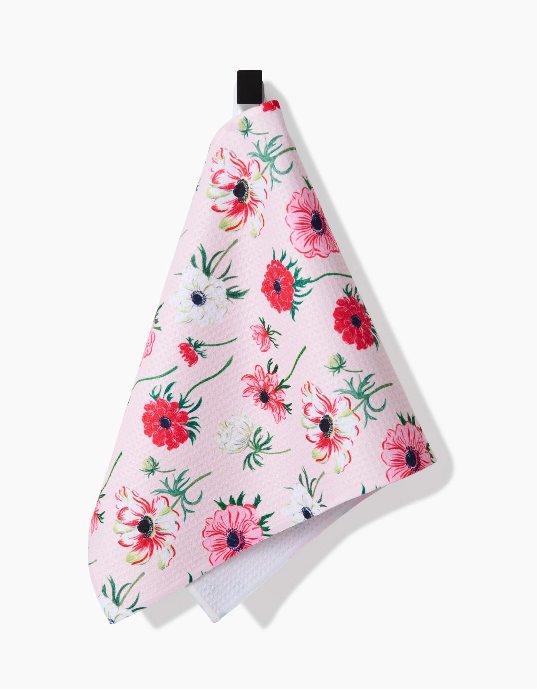 The Linda Fox Anemone Garden Flowers kitchen bar towel features a pink floral pattern with red, white, and pink flowers, made from recycled materials and hanging by a black loop against a white background.