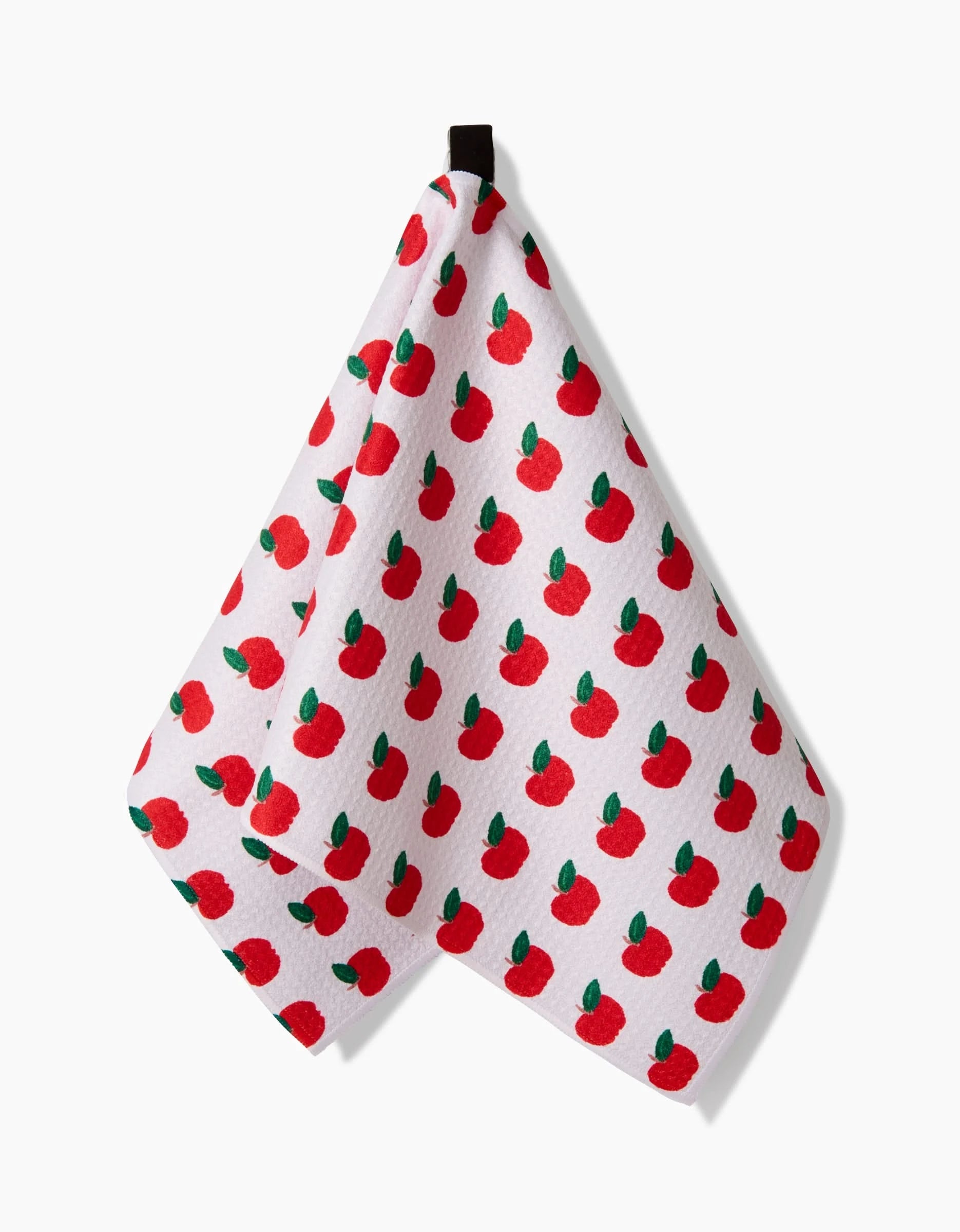 The Brittany Jepsen Apple Grove Bar Towel features a white textured Geoweave fabric with bright red apples and green leaves, hanging on a black loop for easy display.