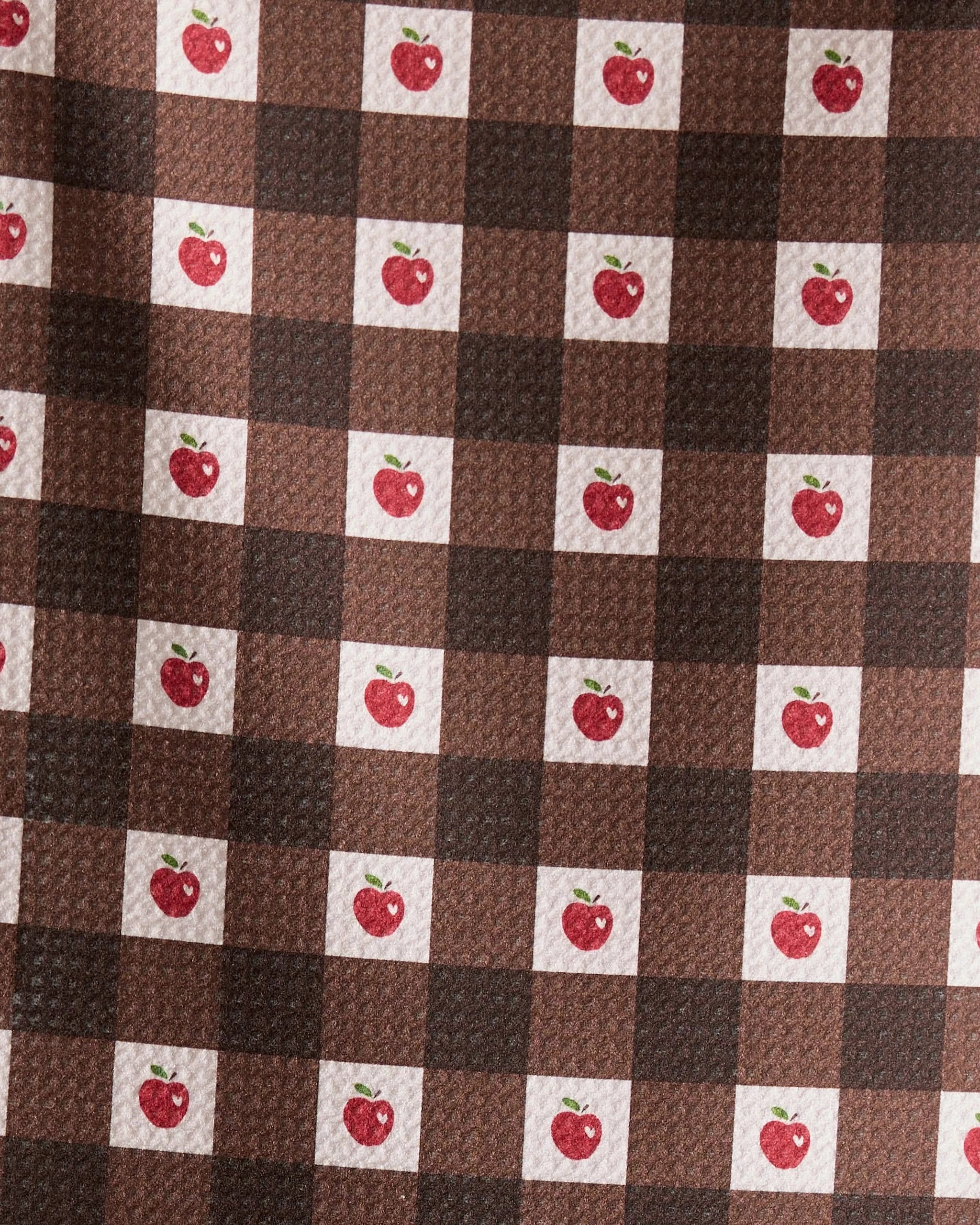 The Geometry Apple Picnic bar towel features a brown and dark brown checkered pattern with small red apples and green leaves in some white squares. Ultra-absorbent and textured, it combines style with function.