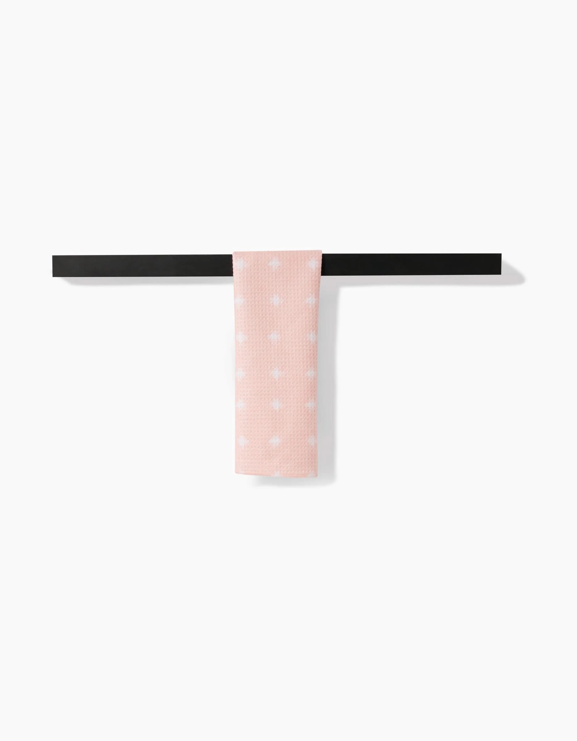 The Amy MacCready Aveline towel, in light pink with white polka dots, hangs neatly on a simple black towel bar against a plain white background.