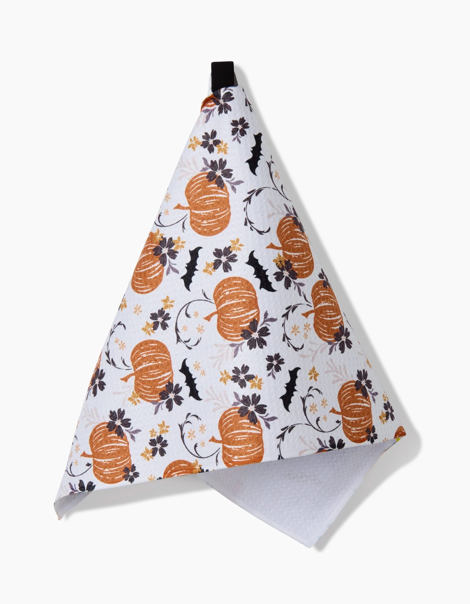 The Bats In The Pumpkin Patch towel by Ashley Celena is a white, ultra-absorbent towel featuring orange pumpkins, black bats, and brown flowers, neatly folded and hanging from a black loop.