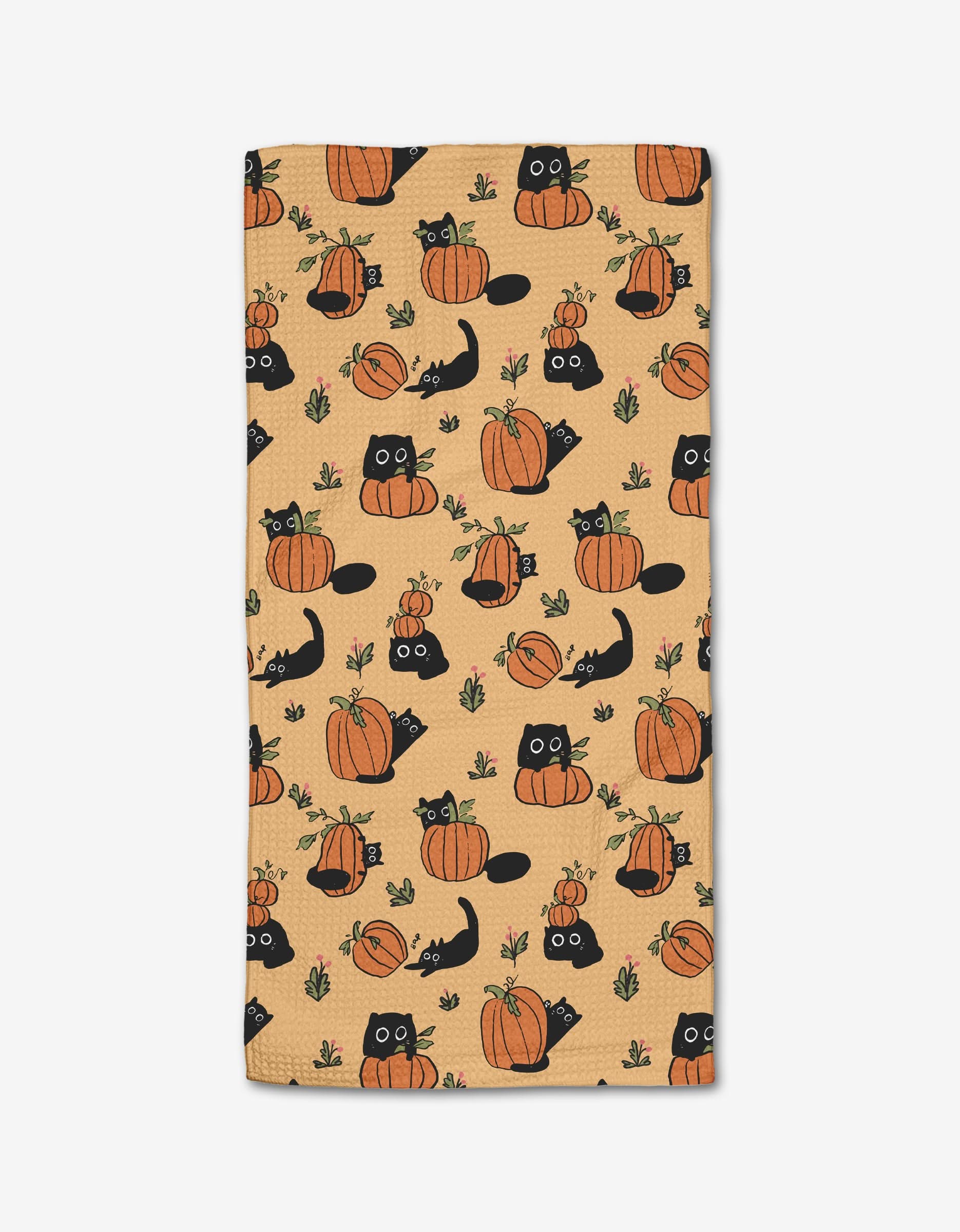 The Black Cats bar towel by Janna Sue Design is made from recycled Geoweave fabric and features a Halloween/autumn motif with black cats and pumpkins among green leaves, combining eco-friendly durability with festive style.
