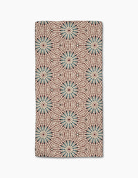 The Katherine Berkeley Blue Aster Foxtrot Bar Towel features ultra-absorbent Geoweave fabric and a kaleidoscopic pattern of blue and red starbursts on beige for a bold, symmetrical look.