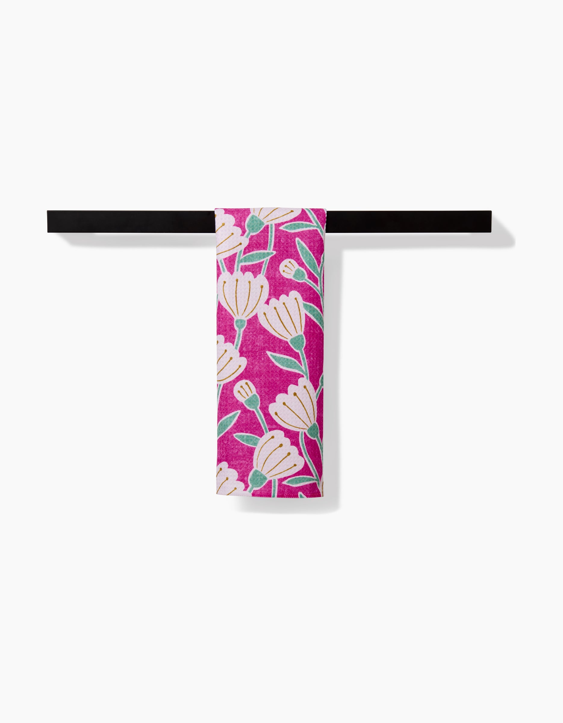 The Clemmie Bar Towel by Amy MacCready, featuring a pink base with white and green floral patterns, made from recycled materials, is displayed on a black towel bar against a white background.