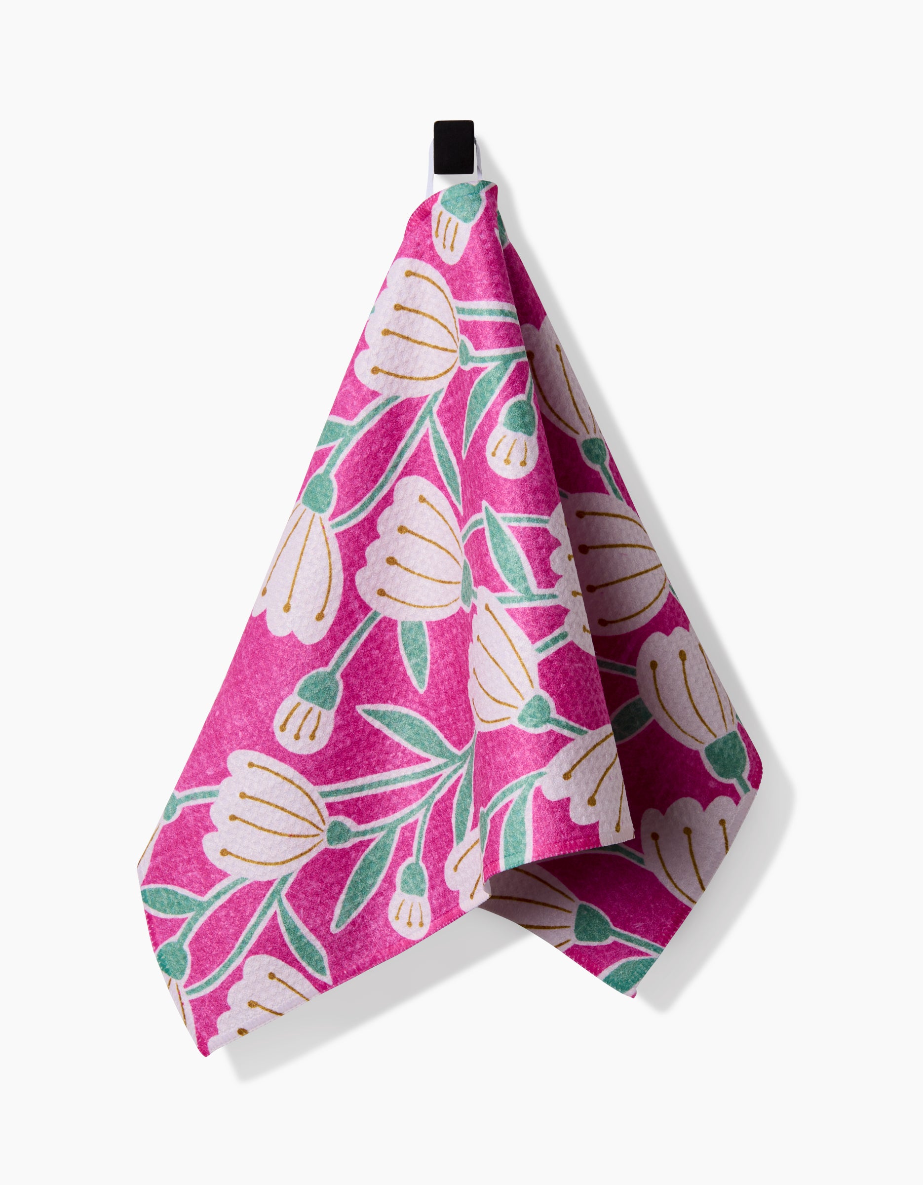 The Clemmie bar towel by Amy MacCready features a pink Geoweave fabric with white flowers and green leaves, hanging from a black hook against a white background.
