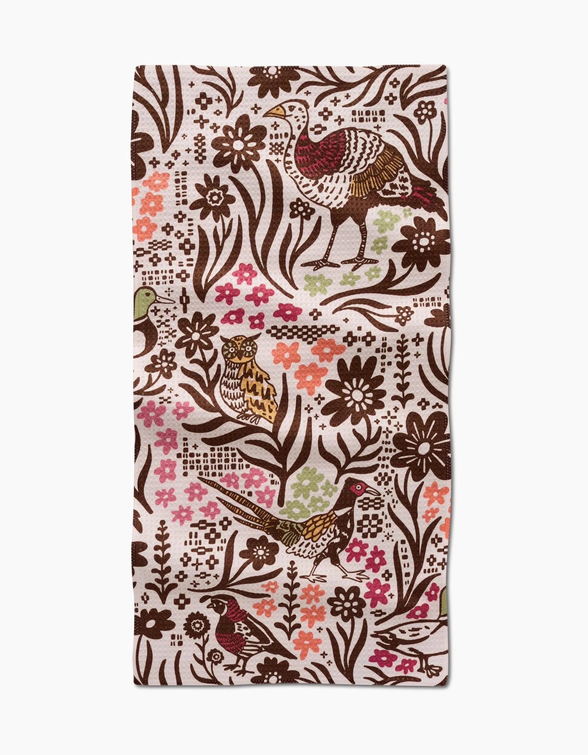 The Kayla Ann Fall Fowl towel is a rectangular, ultra-absorbent piece featuring birds, flowers, and leaves in brown, pink, orange, and green hues on a cream background with an intricate, colorful pattern.
