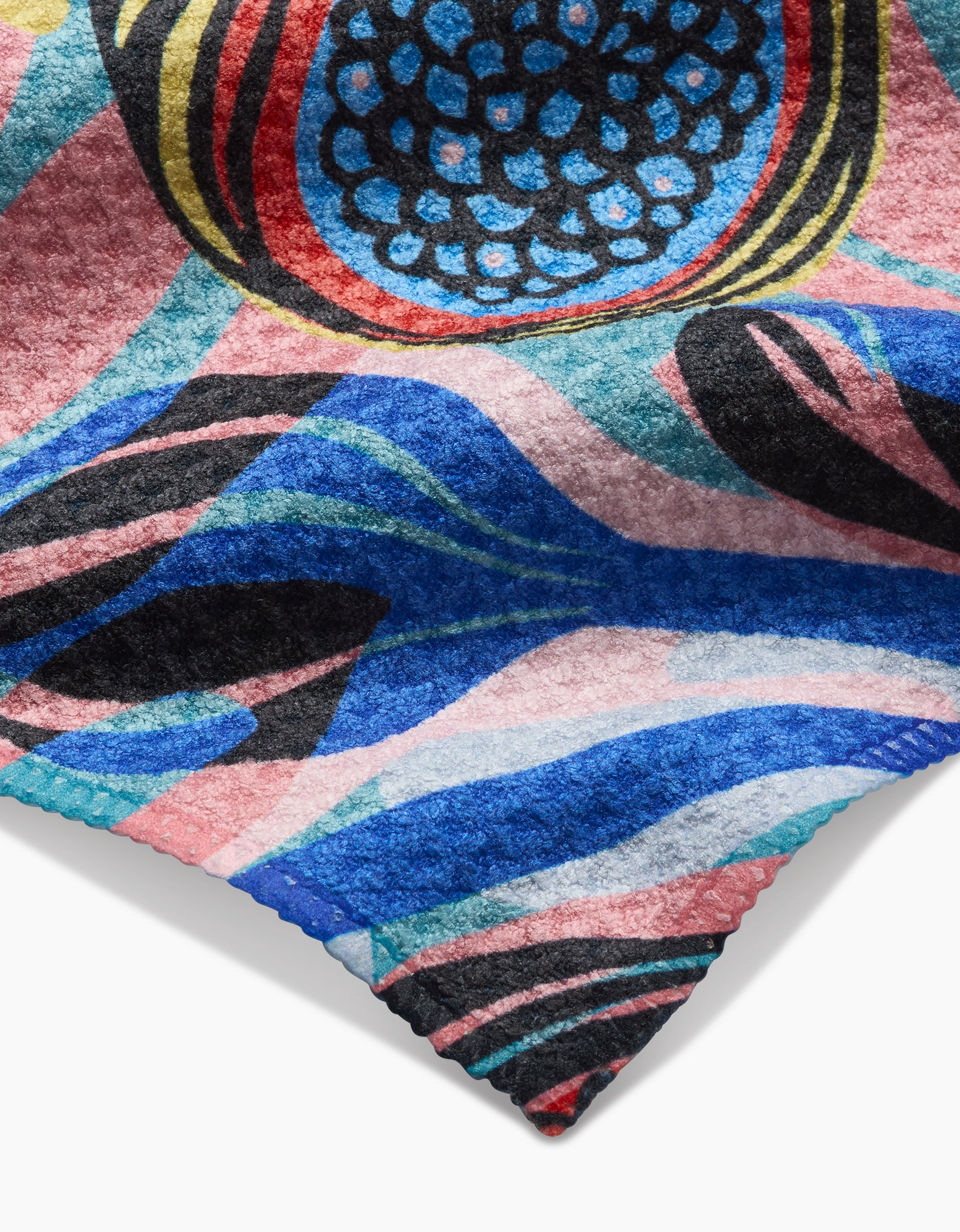 A close-up of the Fig Garden Bar Towel by Masha Volnova, made from Geoweave fabric and featuring bold abstract blue, pink, black, and red patterns with circular and wavy designs and a signature jagged edge.
