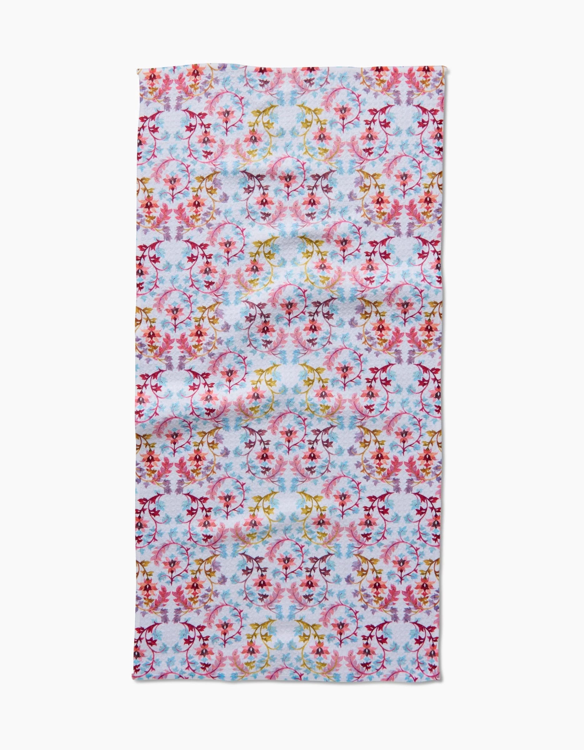 The Maayan Alper-Swan Folk Tapestry bar towel, made from recycled materials, showcases a vibrant floral pattern in pinks, reds, yellows, and blues on light blue and is displayed on a white surface.
