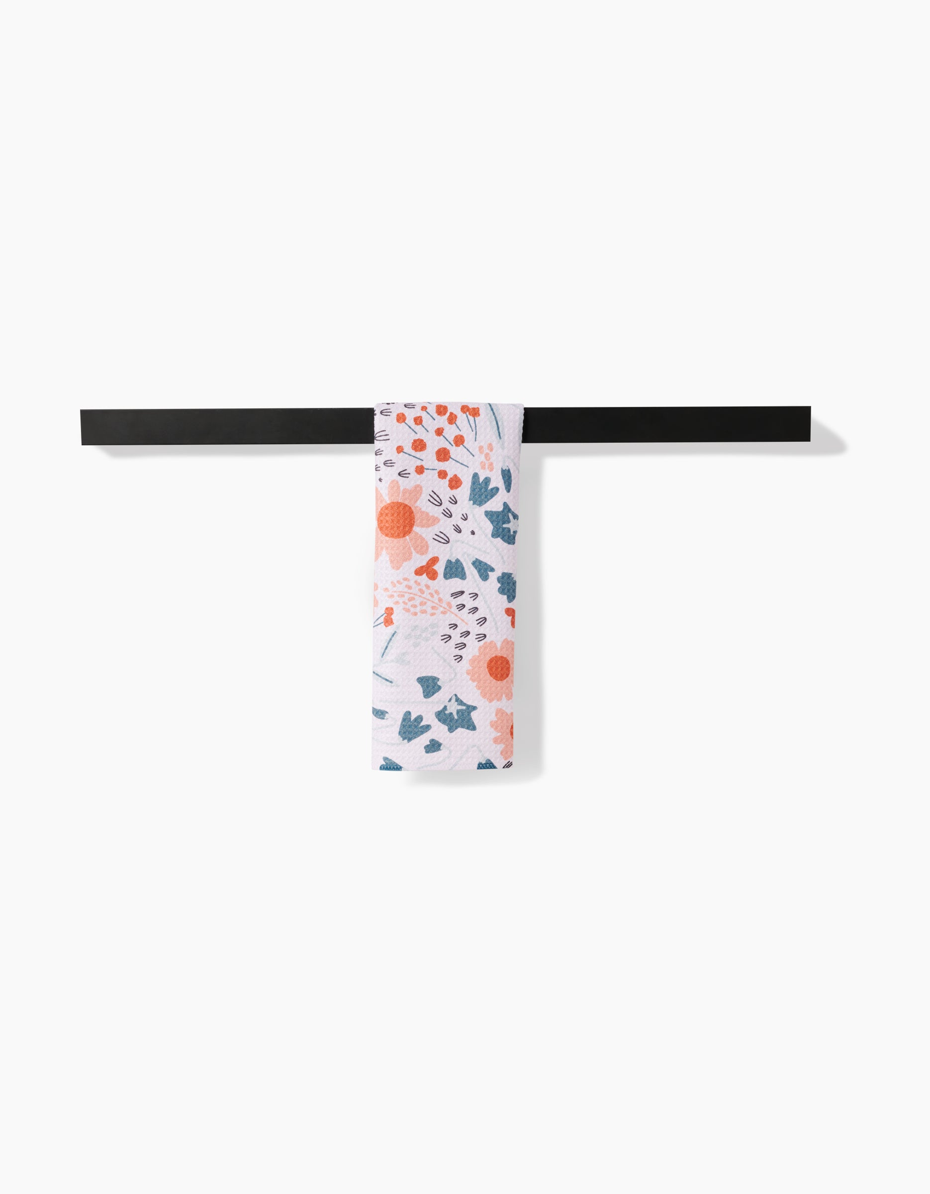 The Forest Foliage patterned bar towel by Coit Creative, made from absorbent Geoweave fabric, hangs neatly over a sleek black towel bar against a white background.