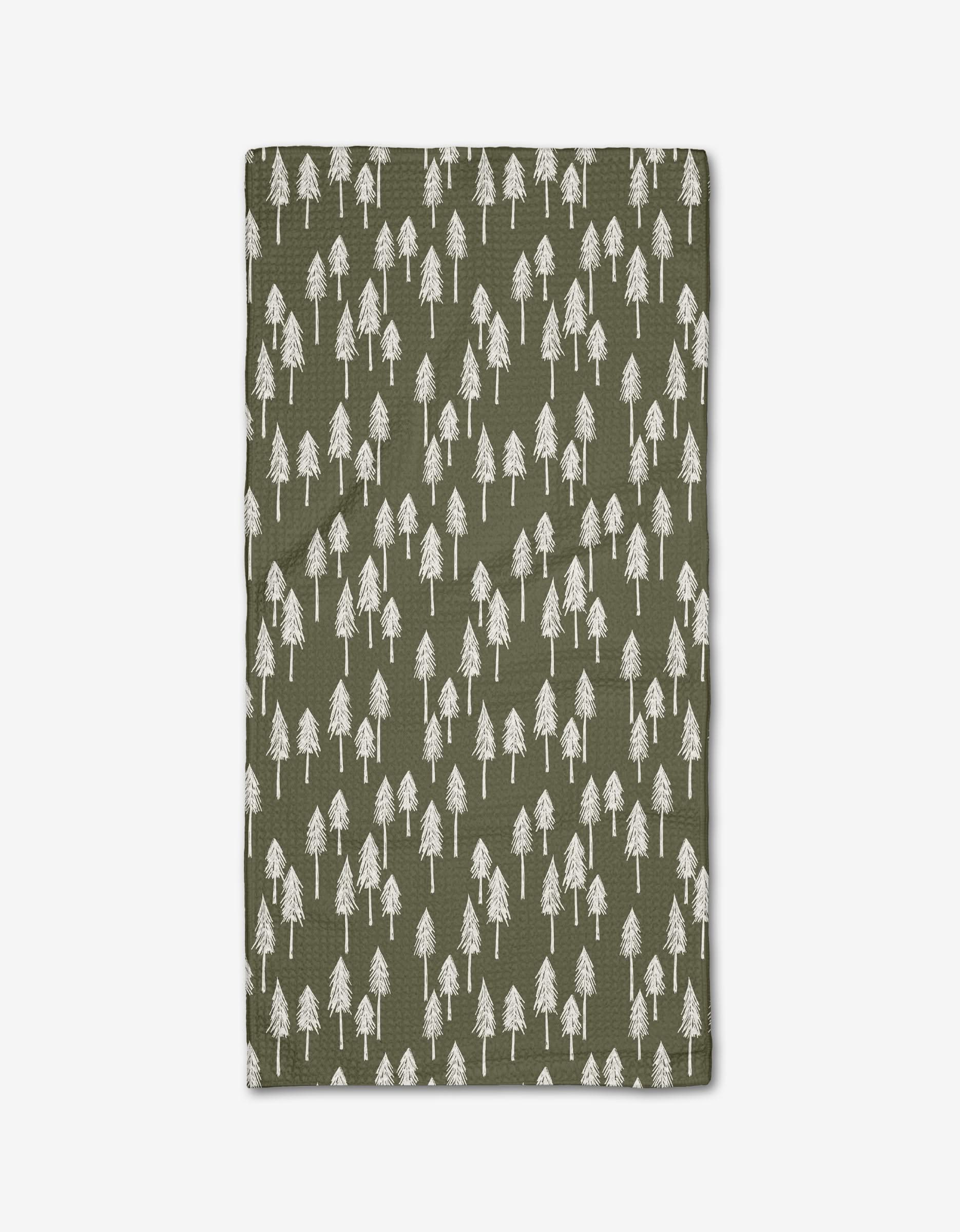 The Forrest Hill blanket by Hufton Studio is green, crafted from recycled materials, and displays a repeating pattern of white hand-drawn pine trees across its surface.