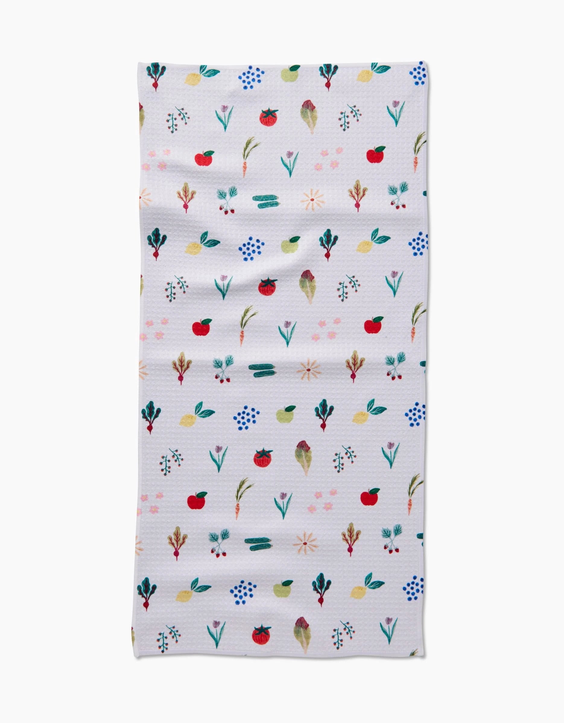 The Fresh Produce Geoweave cloth by Brittany Jepsen is a rectangular, ultra-absorbent white towel adorned with colorful, hand-painted flowers, leaves, and red fruits arranged in horizontal rows.