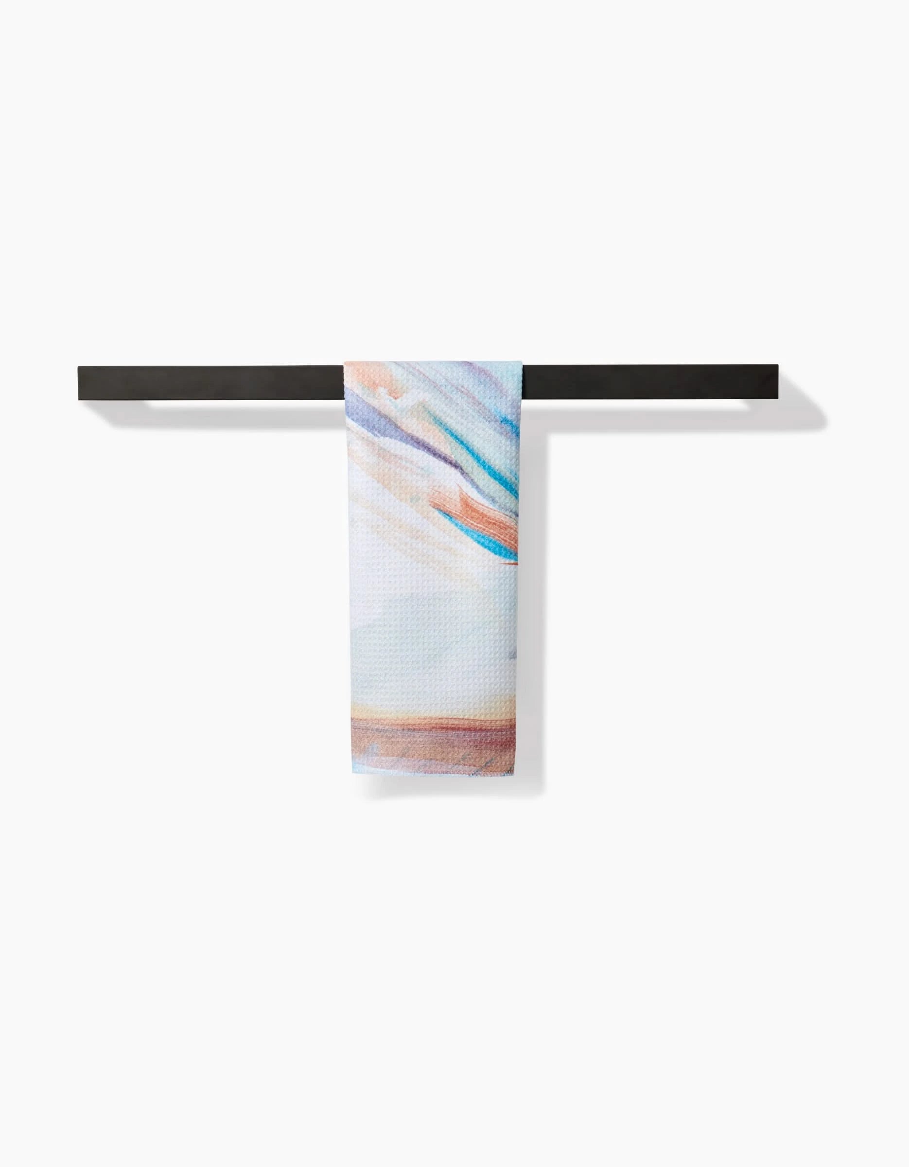The Golden Hour in the Rockies bar towel by Kelly Peters, featuring pastel abstract patterns on Geoweave fabric, hangs neatly on a simple black rack against a plain white background.