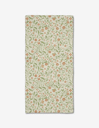 The Hawthorns Bar Towel by Danelys Sidron is rectangular, beige, and made from recycled materials, showcasing an all-over floral design with small orange flowers and green leafy vines, shown flat on a white background.