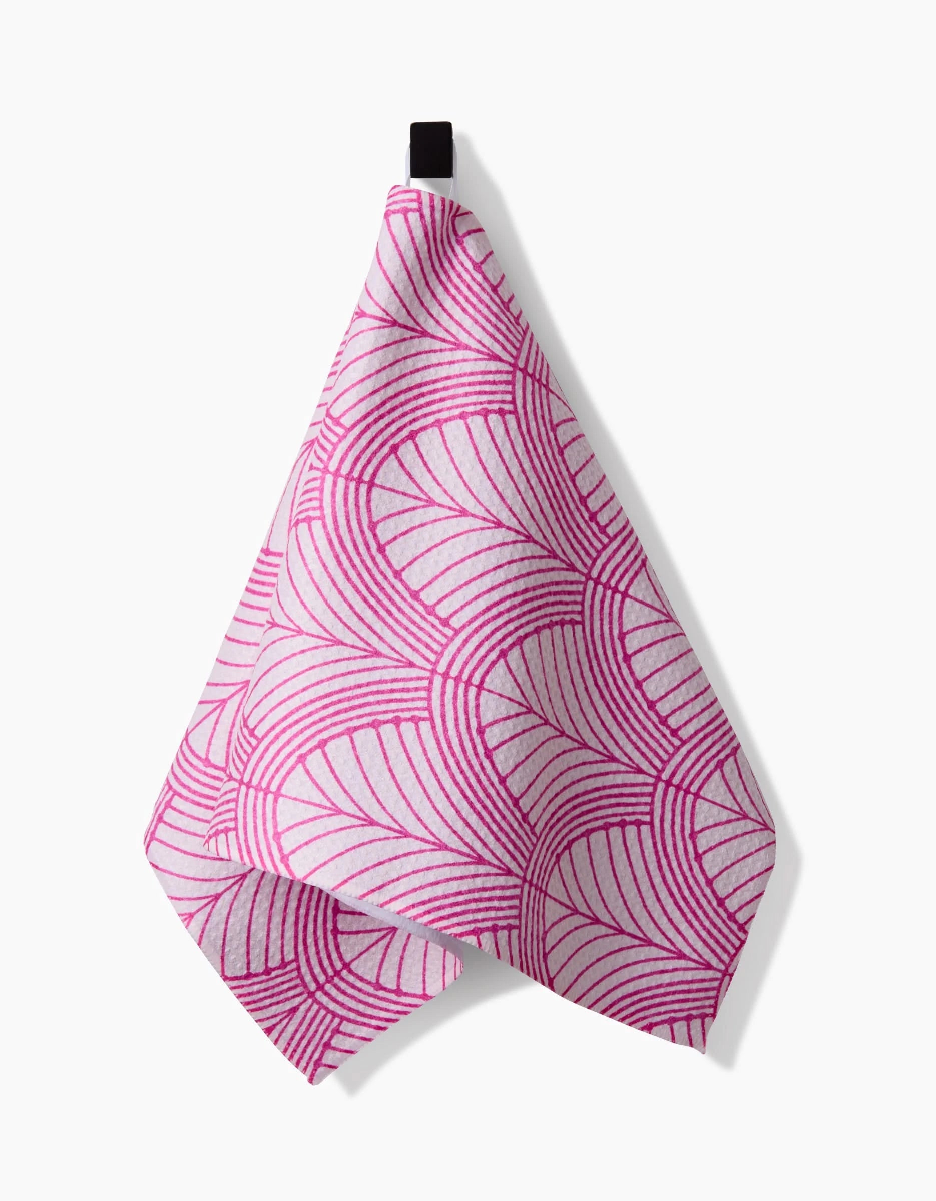 The Amy MacCready Jaskin bar towel, made from Geoweave fabric, features a bold pink geometric curved line pattern on white and hangs from a black loop against a plain white background.