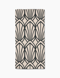 The Amy MacCready Jocelyn bar towel is beige, rectangular, made from Geoweave fabric, and features a bold black geometric pattern of stylized fan shapes or arches.
