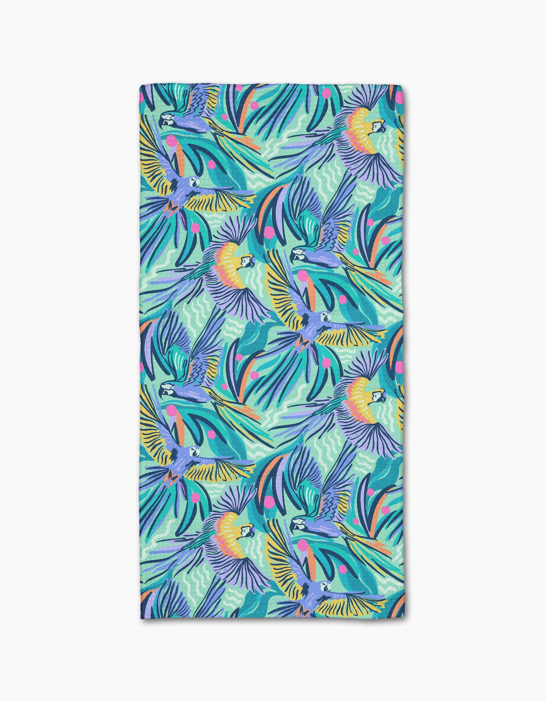 The Jungle Birds beach towel by Masha Volnova features a vibrant tropical pattern with colorful parrots and palm leaves in blue, green, yellow, and pink on a white Geoweave fabric.