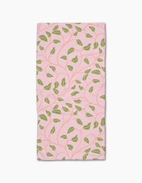 Leafy Maze by Jasmine Blooms Designs: a rectangular pink bar towel crafted from recycled materials, adorned with green leaves and curving vines.