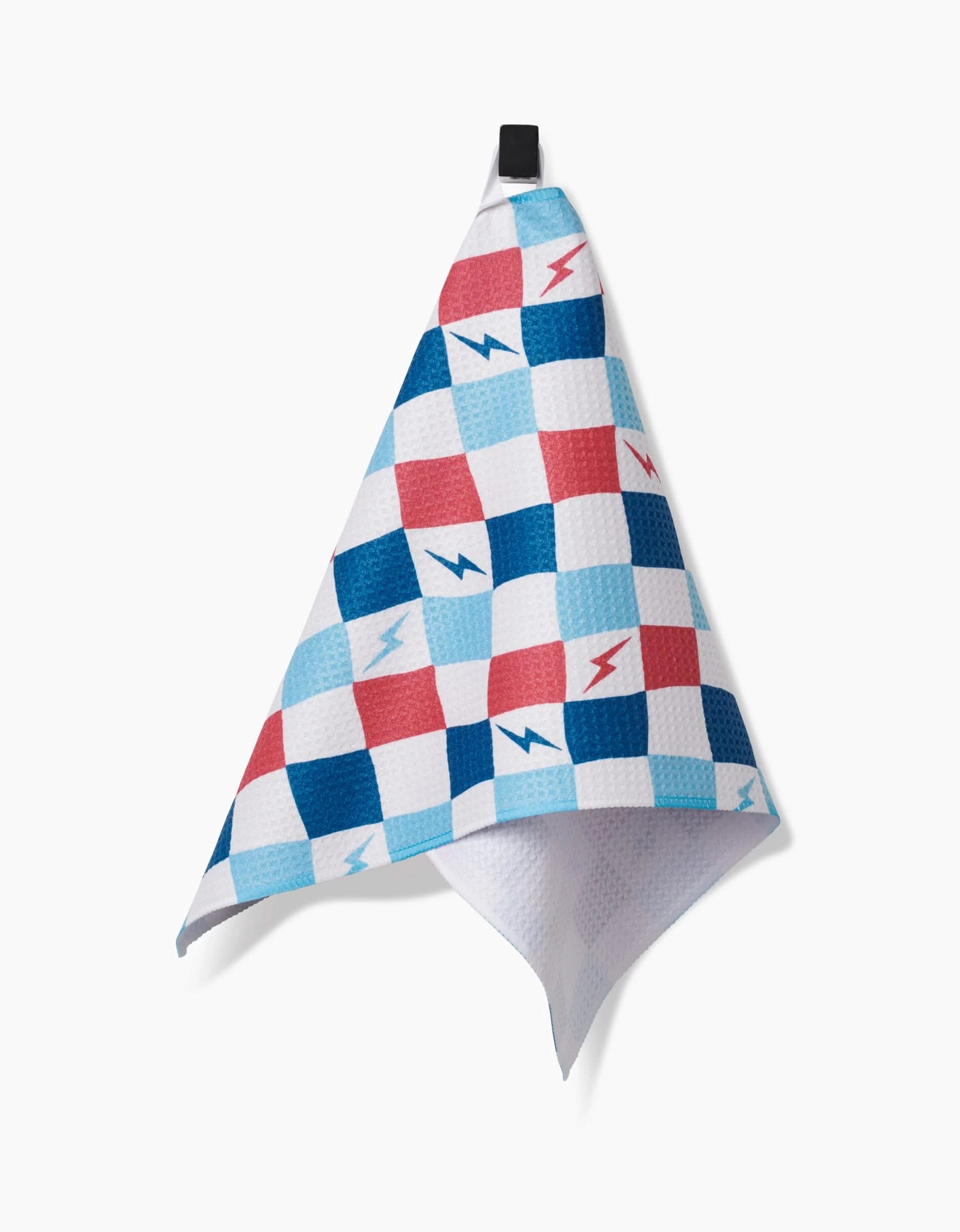 The Hufton Studio “Lightening Bolt Chess” bar towel features a red, blue, and white checkered pattern with small lightning bolt icons. Made from Geoweave fabric for superior absorbency and durability, it hangs from a black loop against a white background.