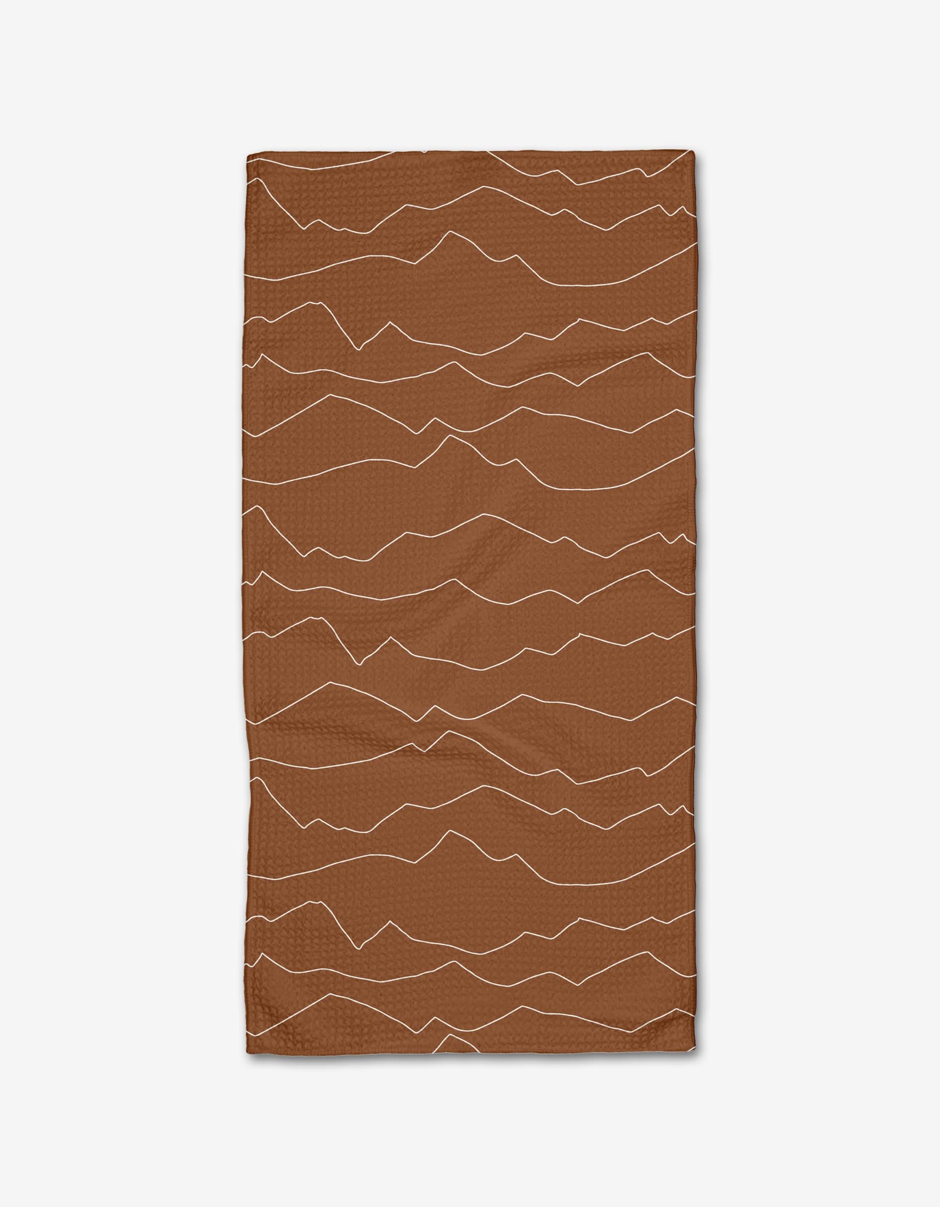 The Lined Mountains Bar Towel by Coit Creative is a rectangular brown towel with wavy, light tan lines resembling mountains, made from Geoweave fabric and shown on a white background.
