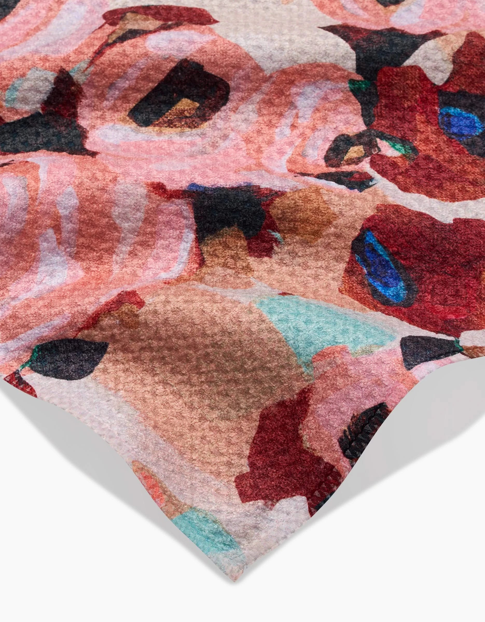 Close-up of the ultra-absorbent Lucia towel by Ania Zwara Art, featuring a textured surface and a vibrant abstract pattern in pink, red, beige, black, blue, and turquoise tones against a white background.