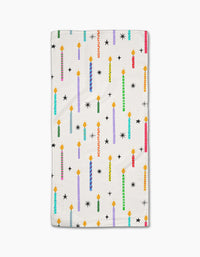 The Make A Wish bar towel by Vaishali Design Studio features colorful, lit birthday candles and black star shapes on white Geoweave fabric.