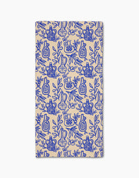 Lisa Nelsons Mediterranean Pour is a rectangular beige cloth napkin made from Geoweave fabric, featuring a blue pattern of stylized vases, jars, and leafy branches in a repeating design.