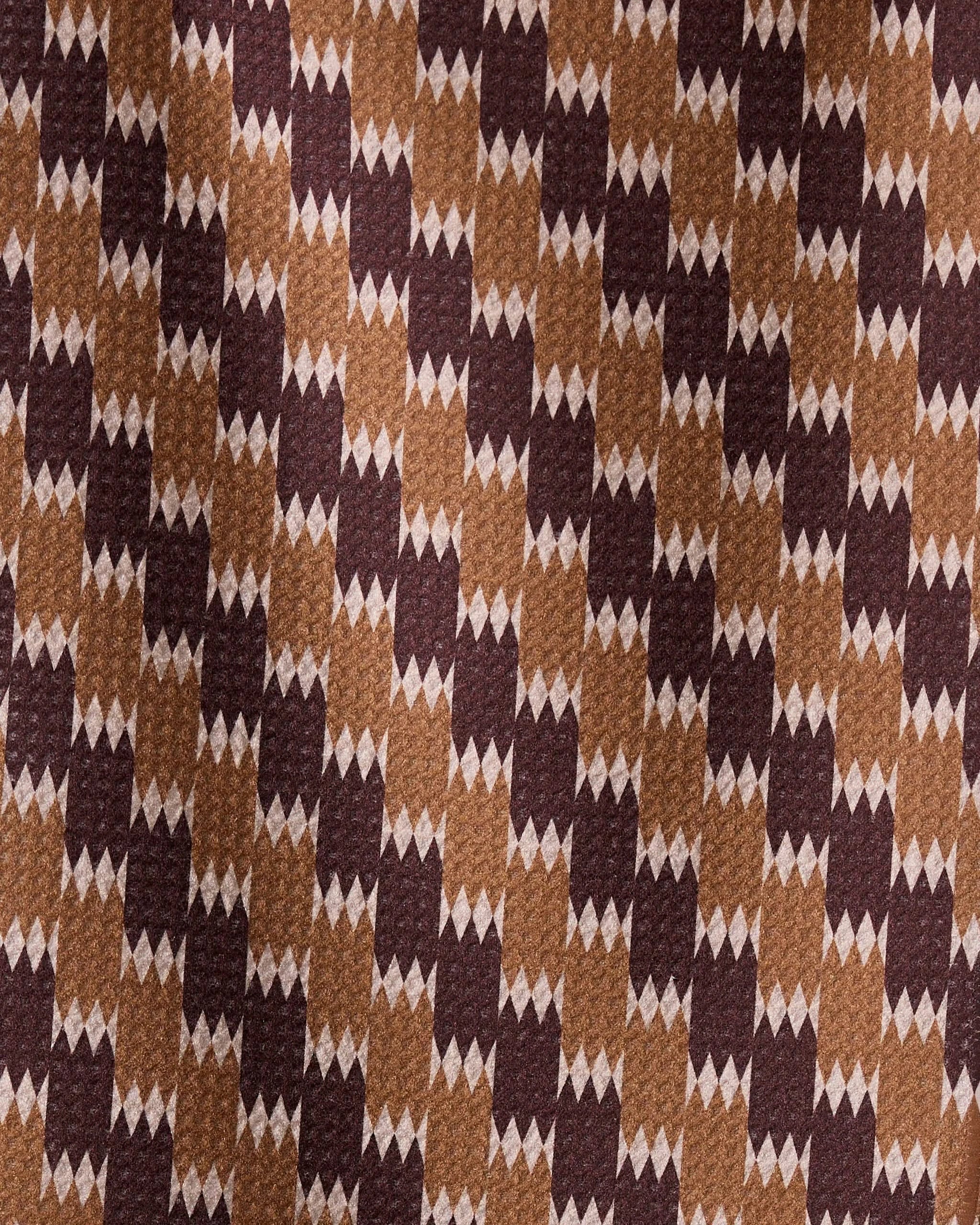 Mountain Song by Geometry is a brown fabric made from recycled materials, featuring dark brown and tan rectangles with small white diamond shapes for a textured, dynamic look.