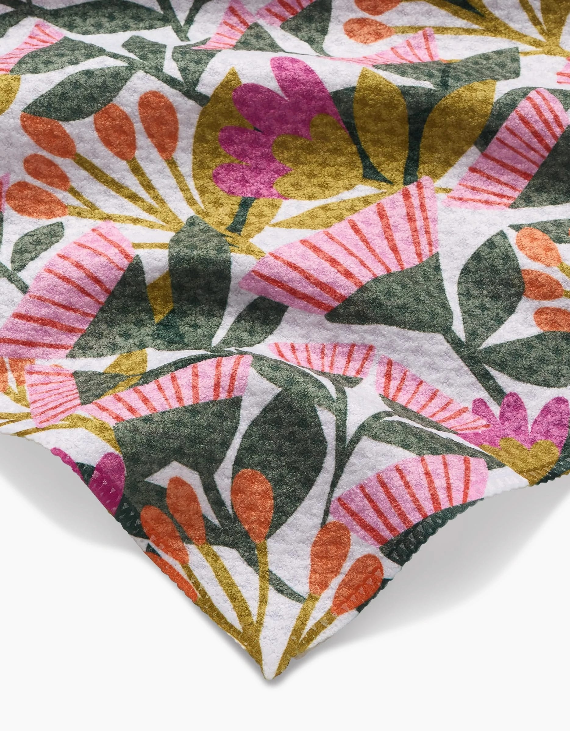 Lisa Nelson’s Moxie Mauve features soft Geoweave fabric with a vibrant floral pattern in pink, orange, and purple flowers plus green leaves on white. The fabric is neatly folded at one corner.