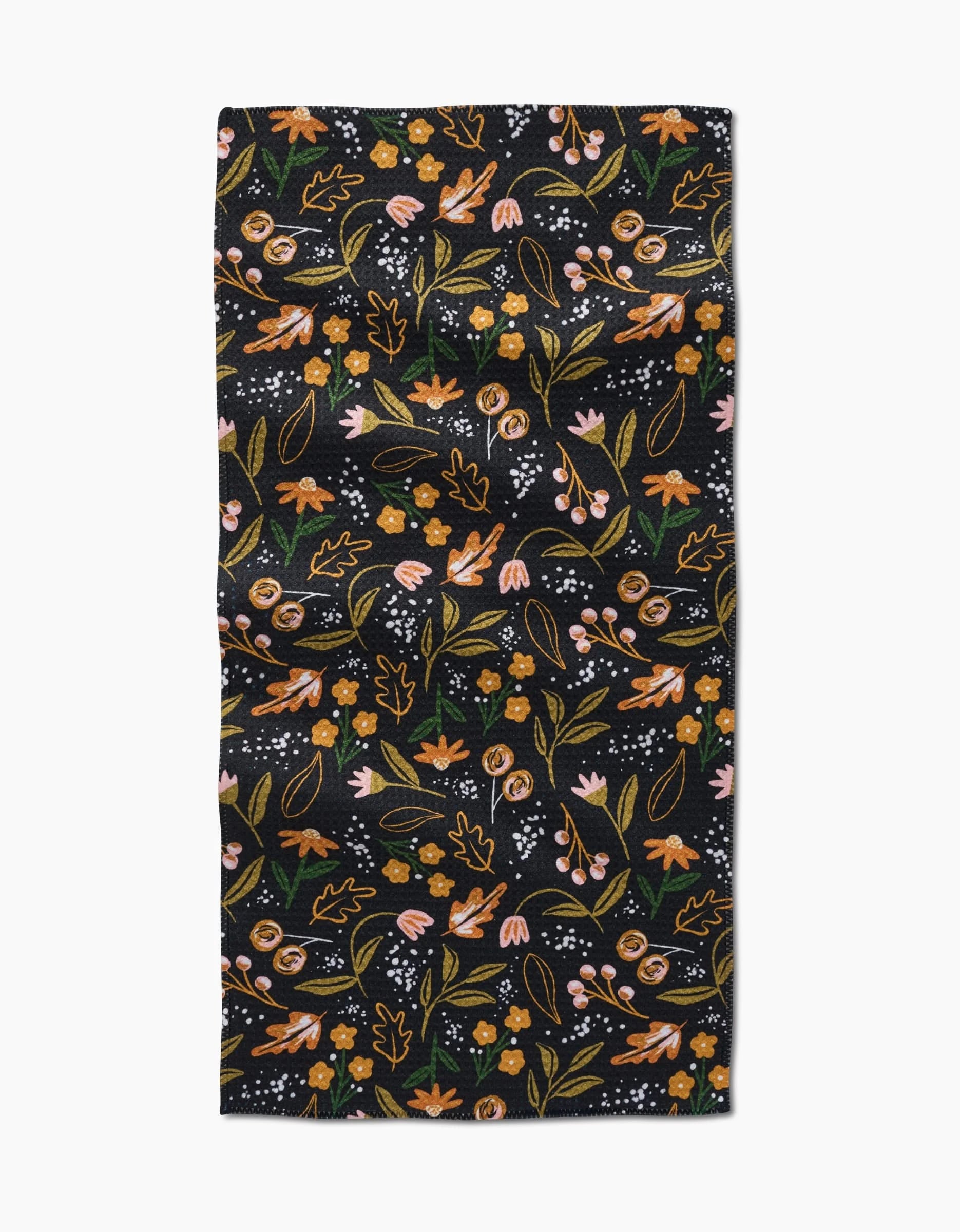 The Nighttime Botanical bar towel by Megan Roy features a rectangular black Geoweave fabric adorned with orange, pink, and yellow flowers, green leaves, and small white dots in a vibrant floral pattern.