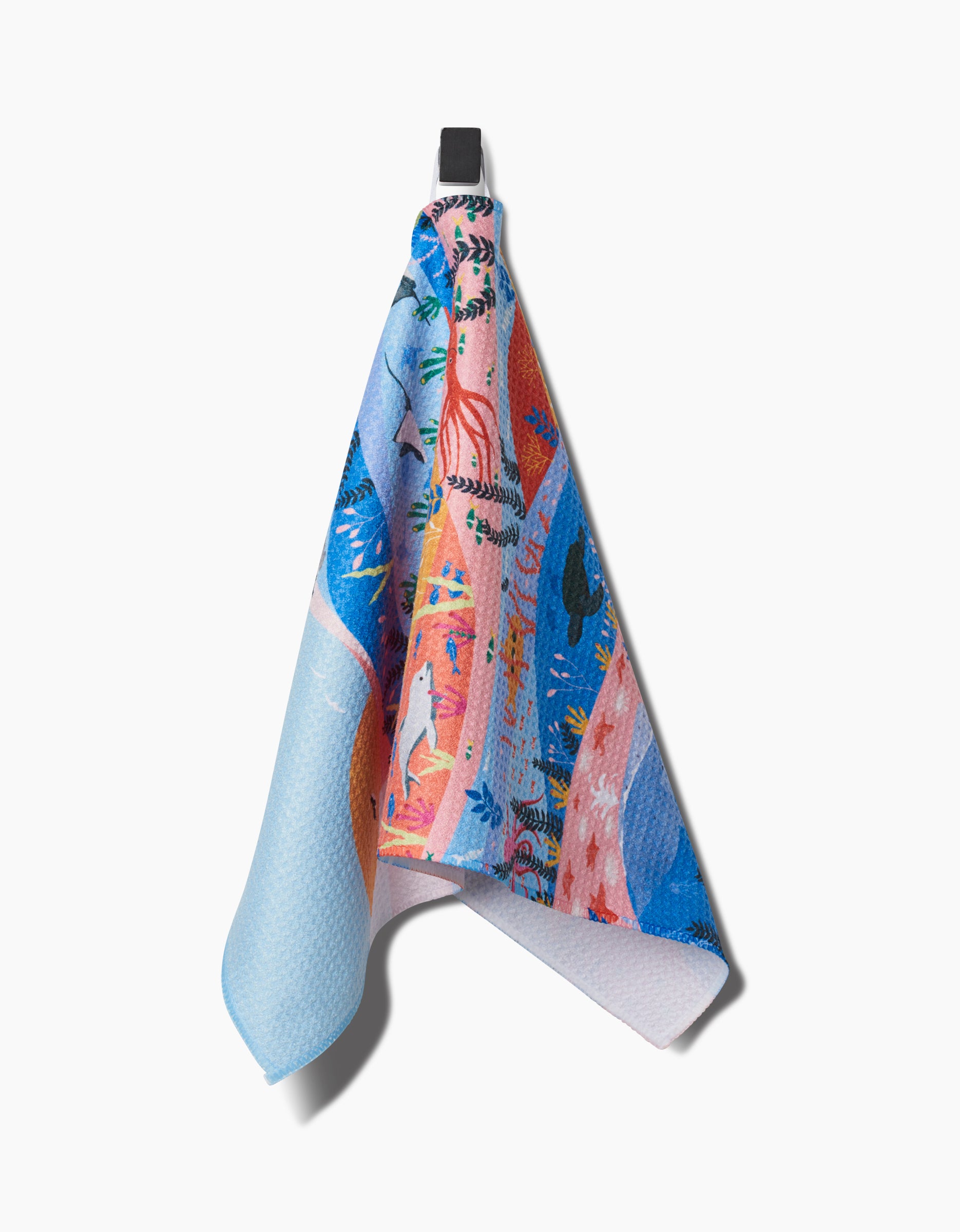 The Oceans bar towel by Ceyda Alasar features a whimsical, illustrated sea creature and abstract design, crafted from recycled materials with a black hanging loop, shown against a white background.