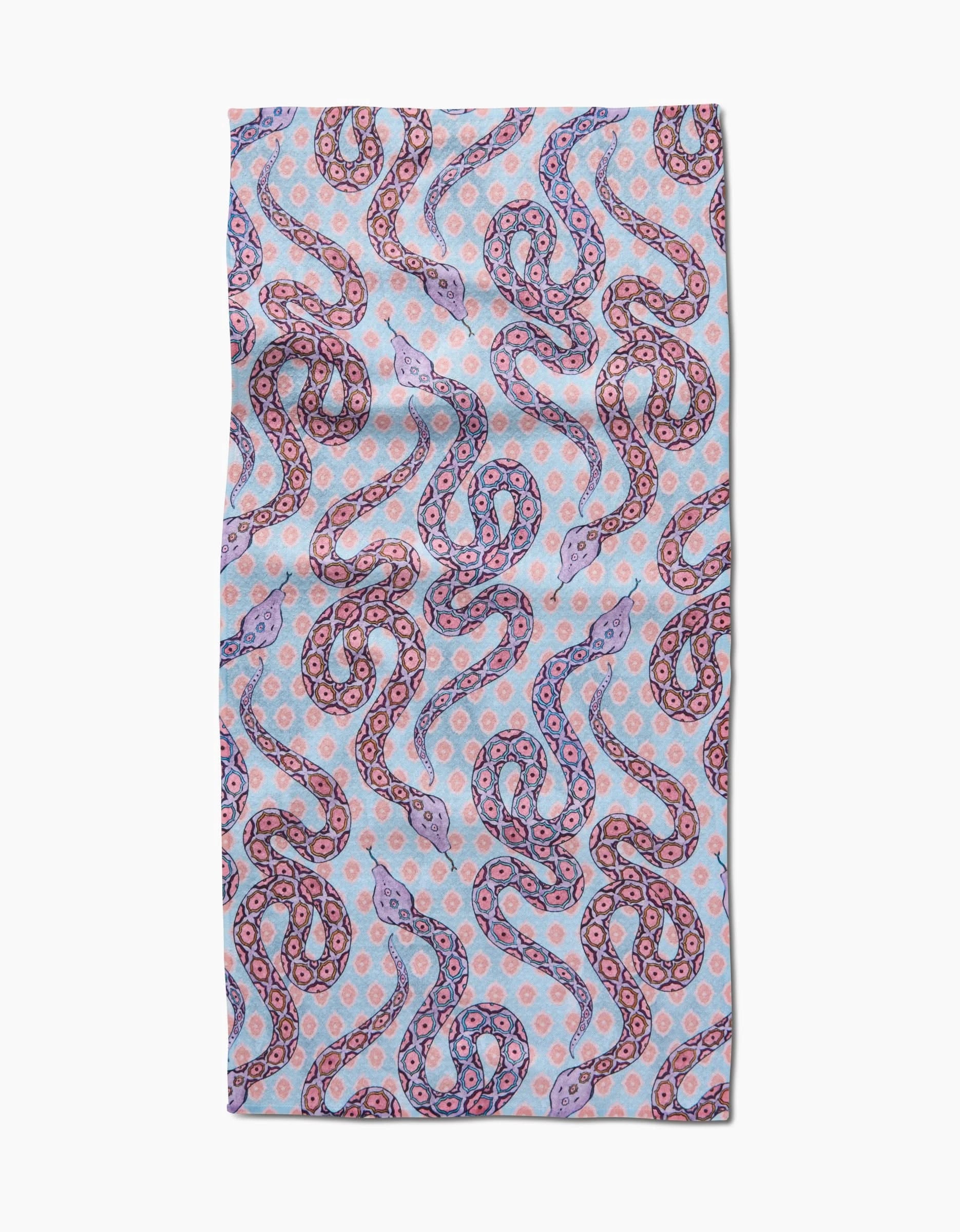 The Ophidia bar towel by Maayan Alper-Swan features a Geoweave fabric with overlapping snakes in pink, purple, and blue on a pastel polka dot background. Ultra-absorbent for stylish and practical use.