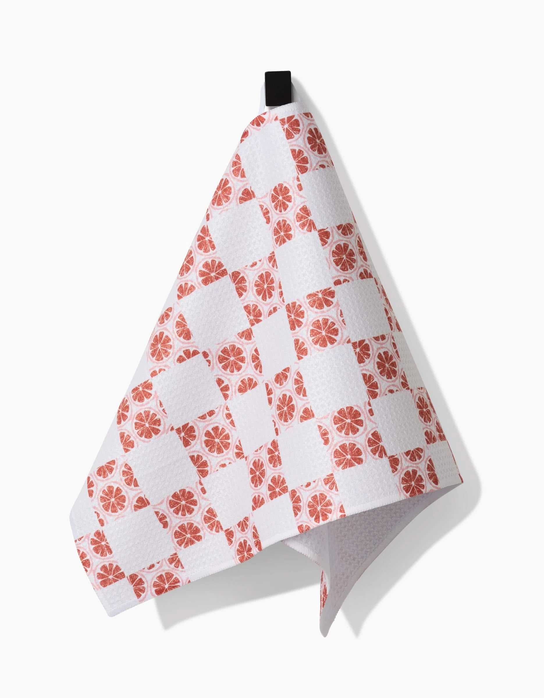 A kitchen towel by Teri the Butter, called Orange Checker, made from Geoweave fabric with an orange checker pattern and a black hanging loop, draped against a white background.