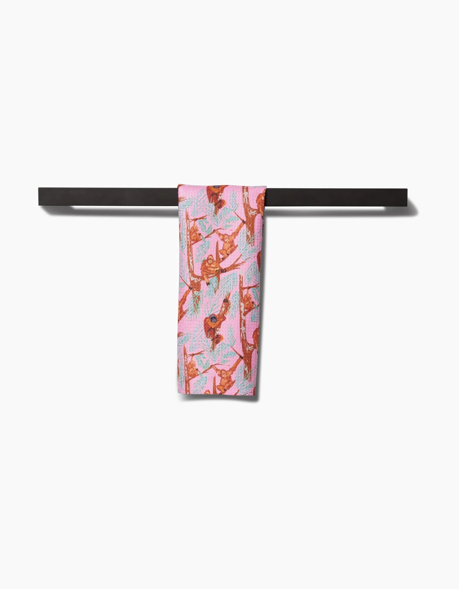 The Orangutan Clan Bar Towel by Elisabeth Wing, made from eco-friendly recycled materials, displays charming orangutan illustrations and hangs neatly over a plain black bar against a white background.