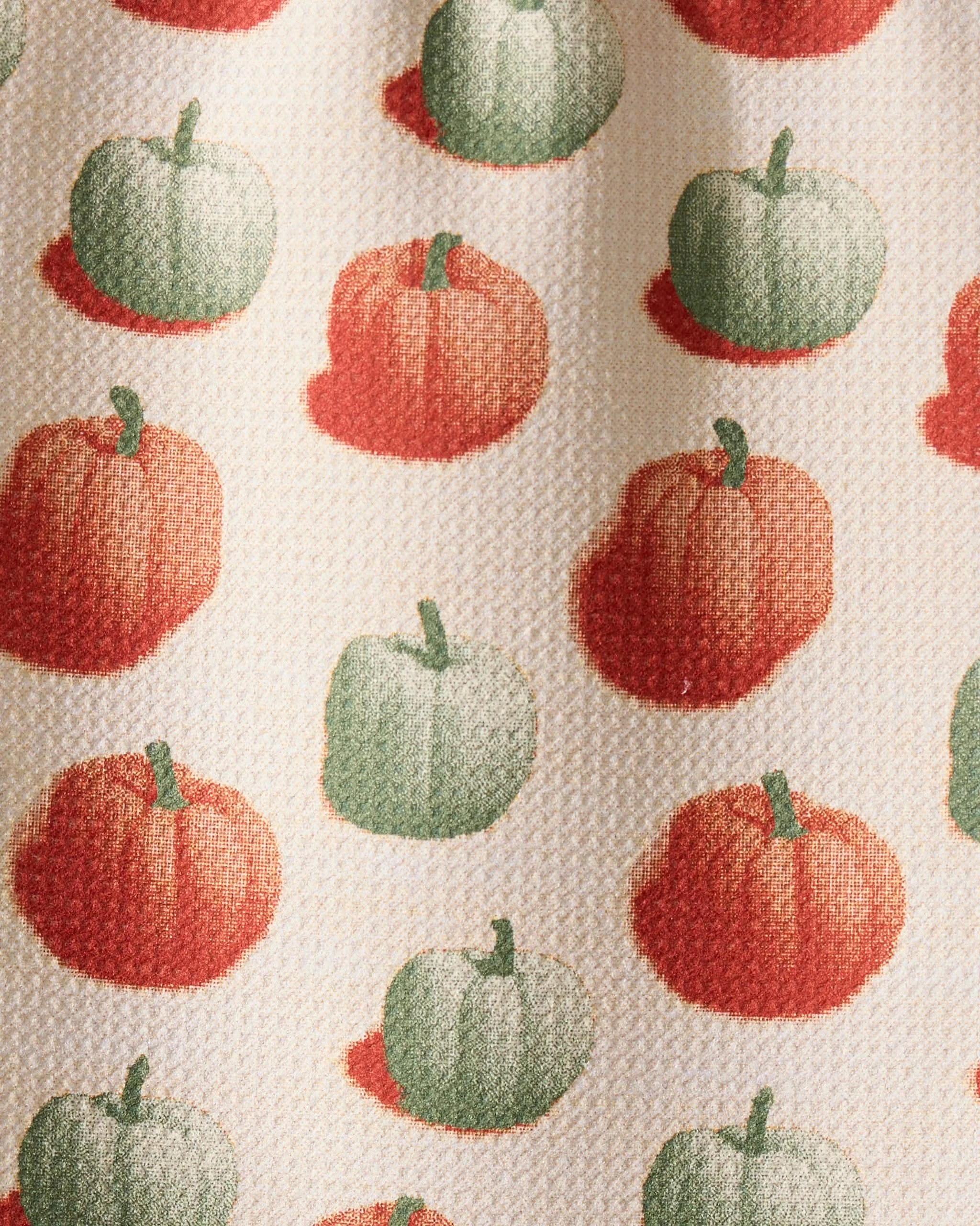 The Geometry Pumpkin Pop bar towel features rows of red-orange and green pumpkins with shadows on a light beige background. Ultra-absorbent with a visible textured finish, it combines function and festive charm.